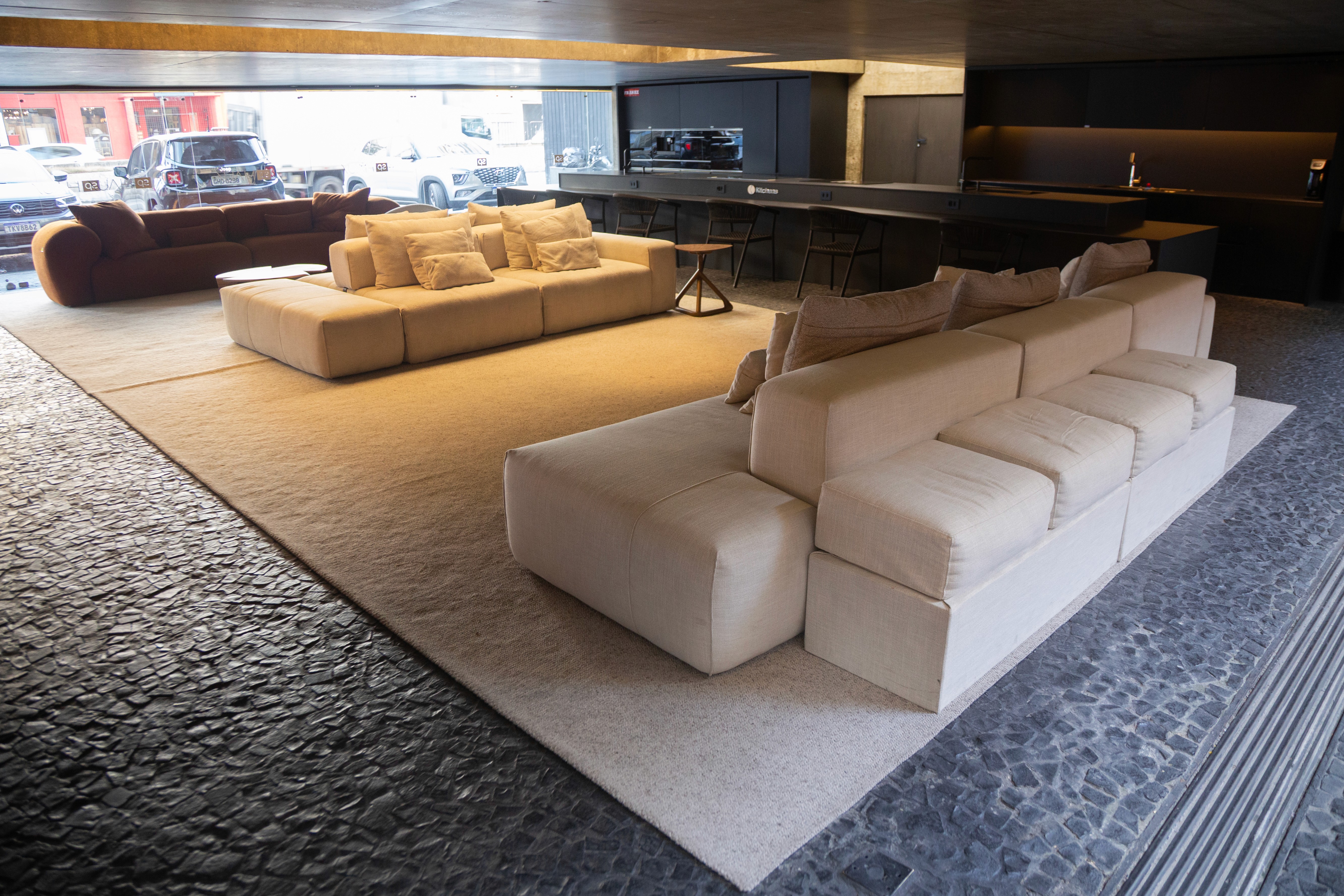 Earth-toned living room with textured walls, beige sofa, dark wood table, and natural light.