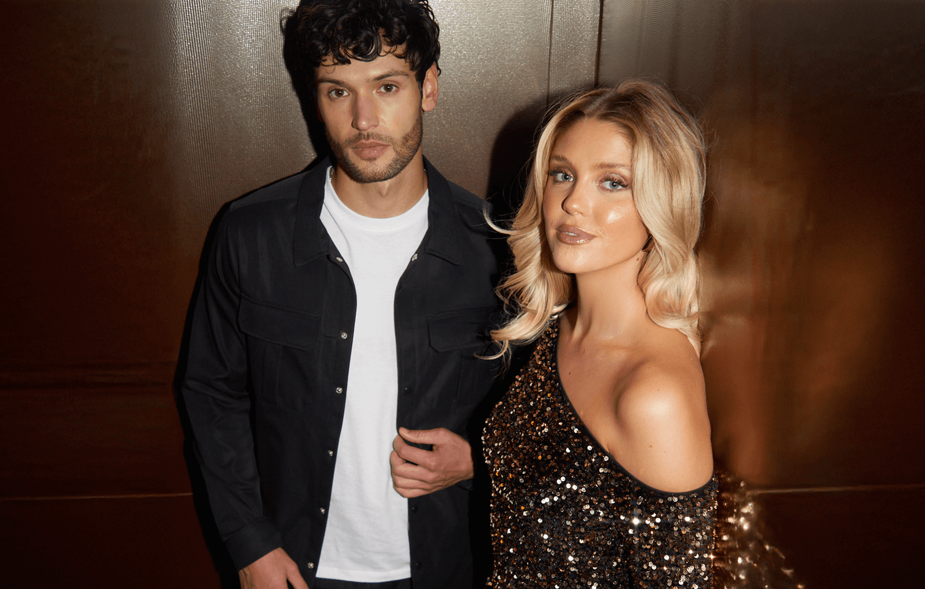 A young man and woman in a fashionable clothes, looking at the camera