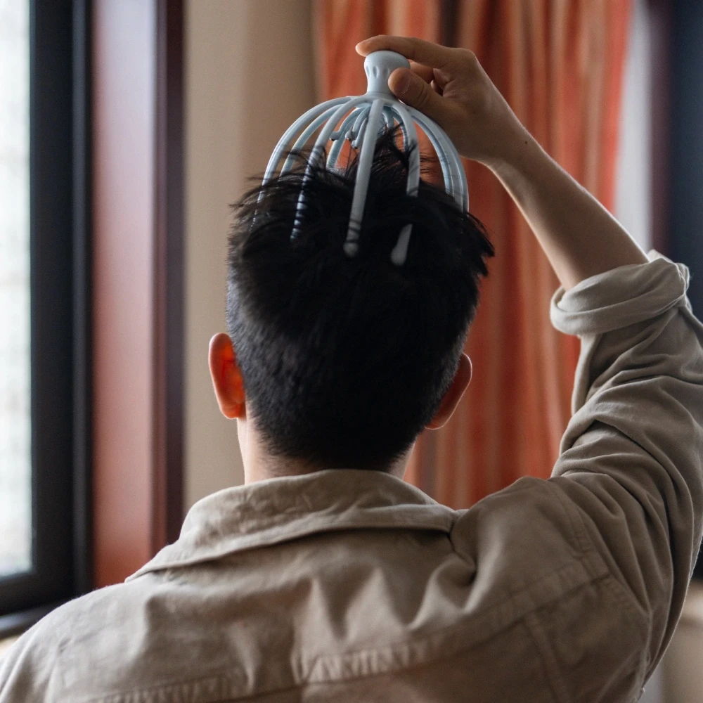 Man using head scratcher/massager
