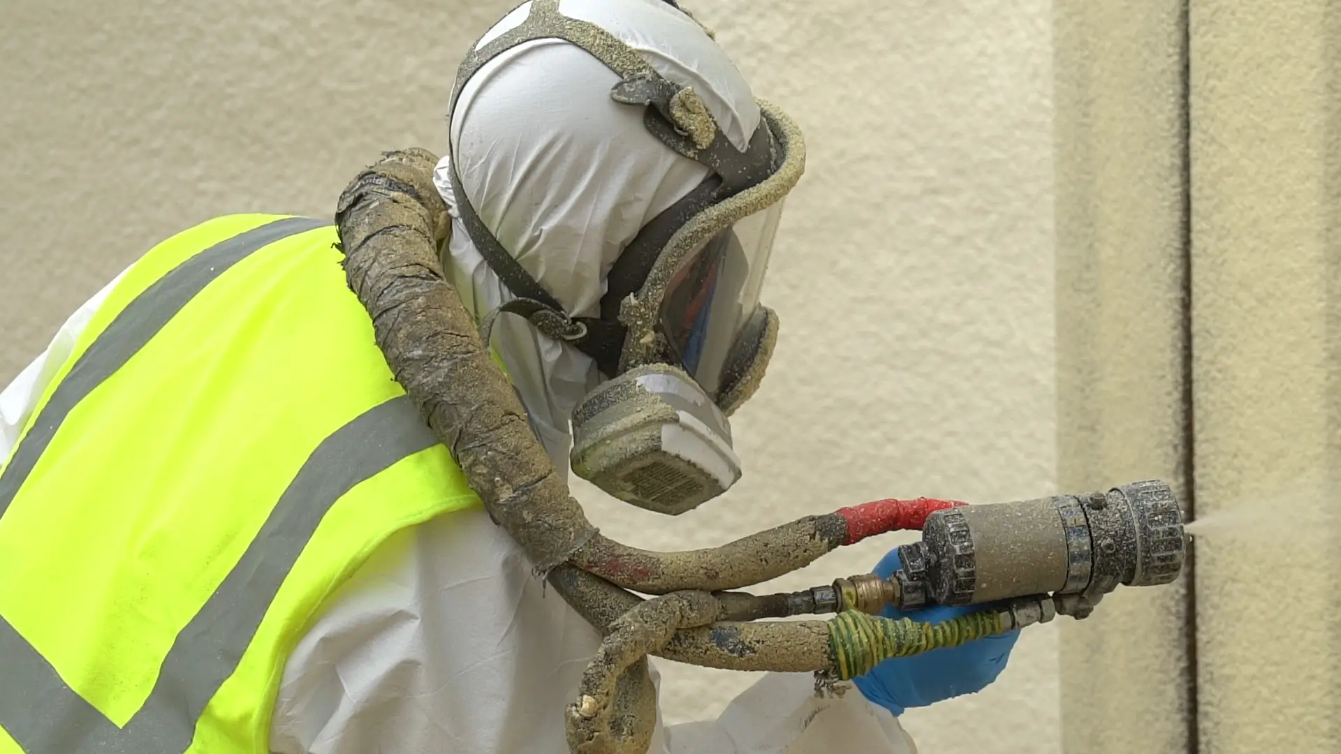 spray foam insulation worker in the process of insulating