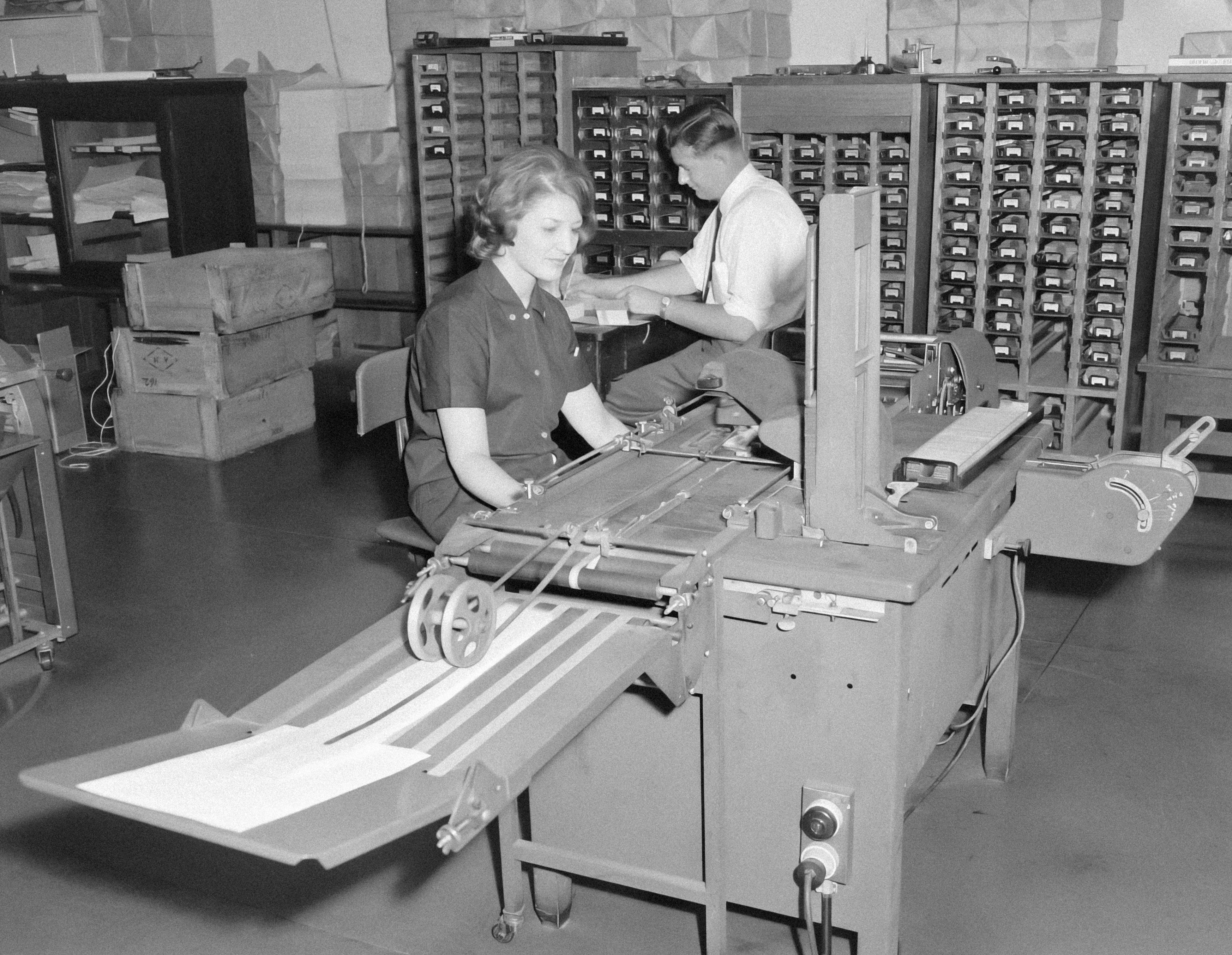 Man and woman working an old printing machine