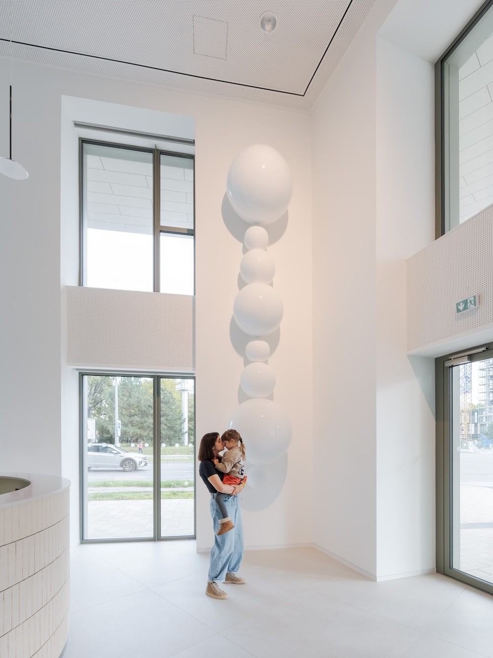 Pohľad dieťaťa na veľký žltý smiley objekt v inštalácii Hlavne sa usmievaj