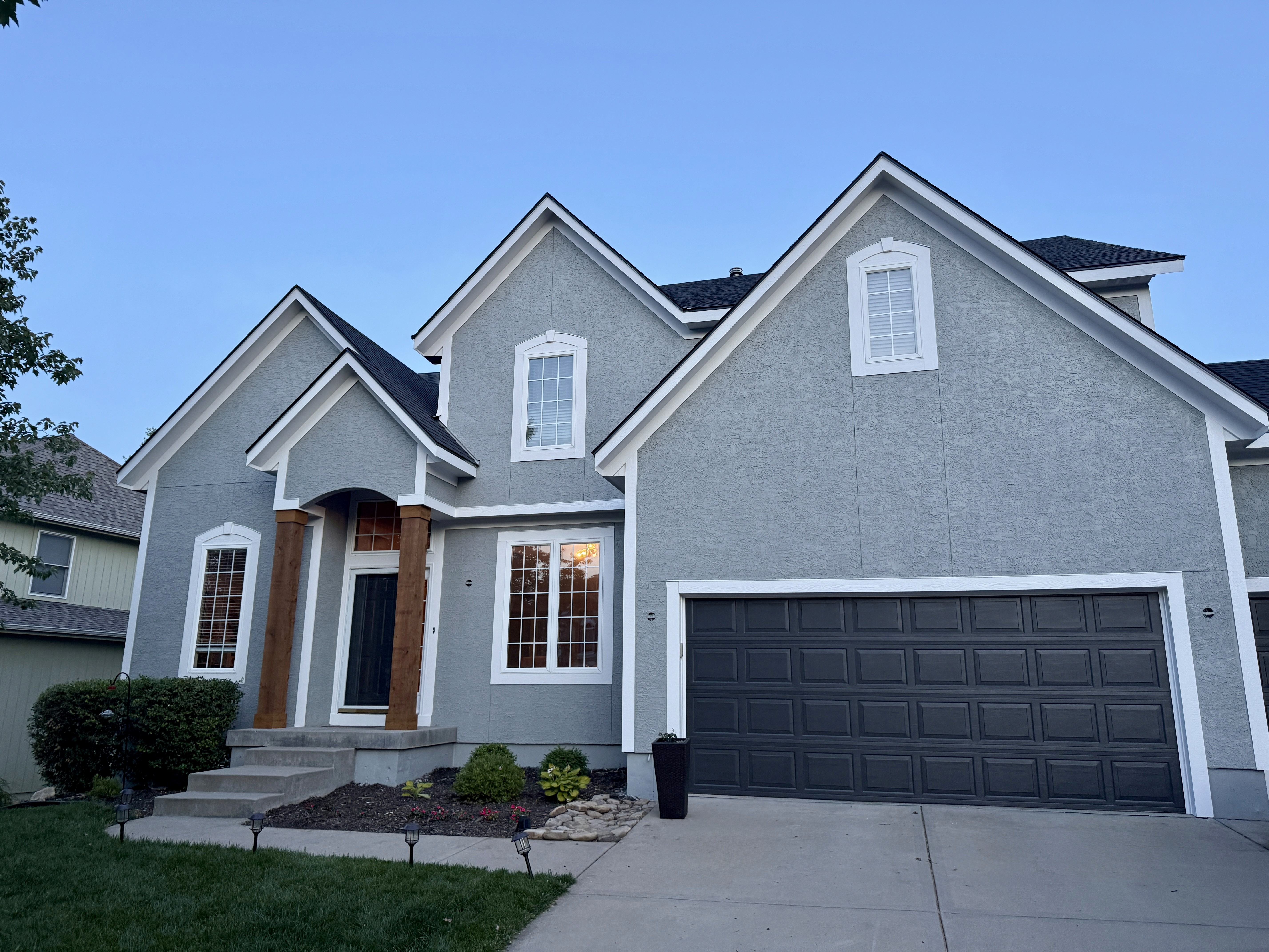 Exterior painting project completed on a Kansas City home in light grey by Gladiator Home Improvement