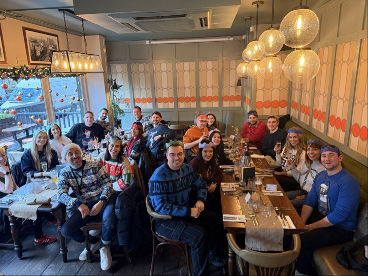 Six people taking a selfie together with a bright outdoor setting behind them.