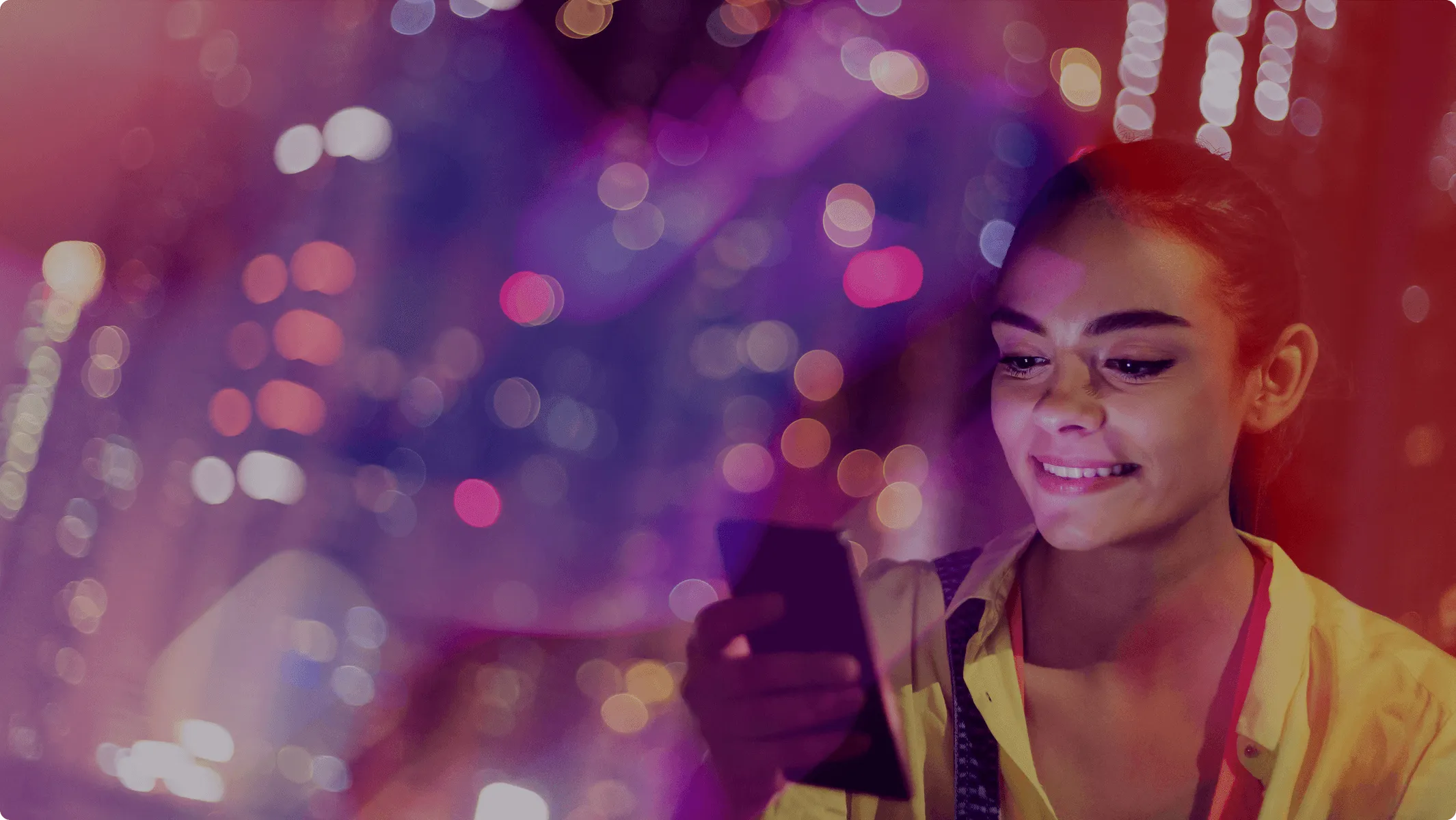 A woman looks at her phone, smilint