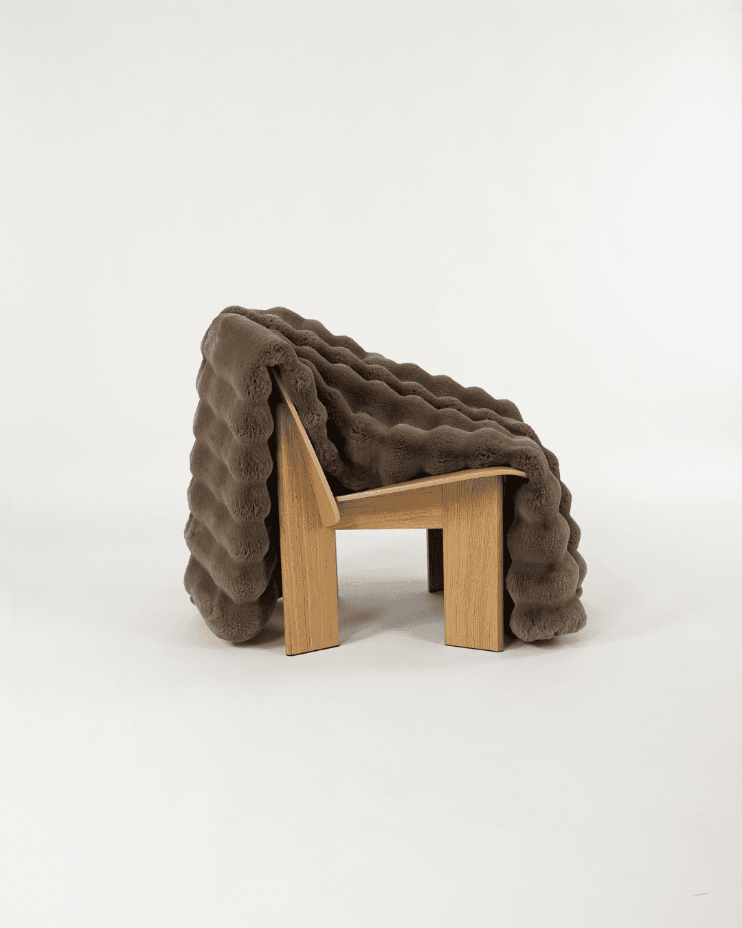 Dimensional faux fur blanket in fungi draped on a wooden chair