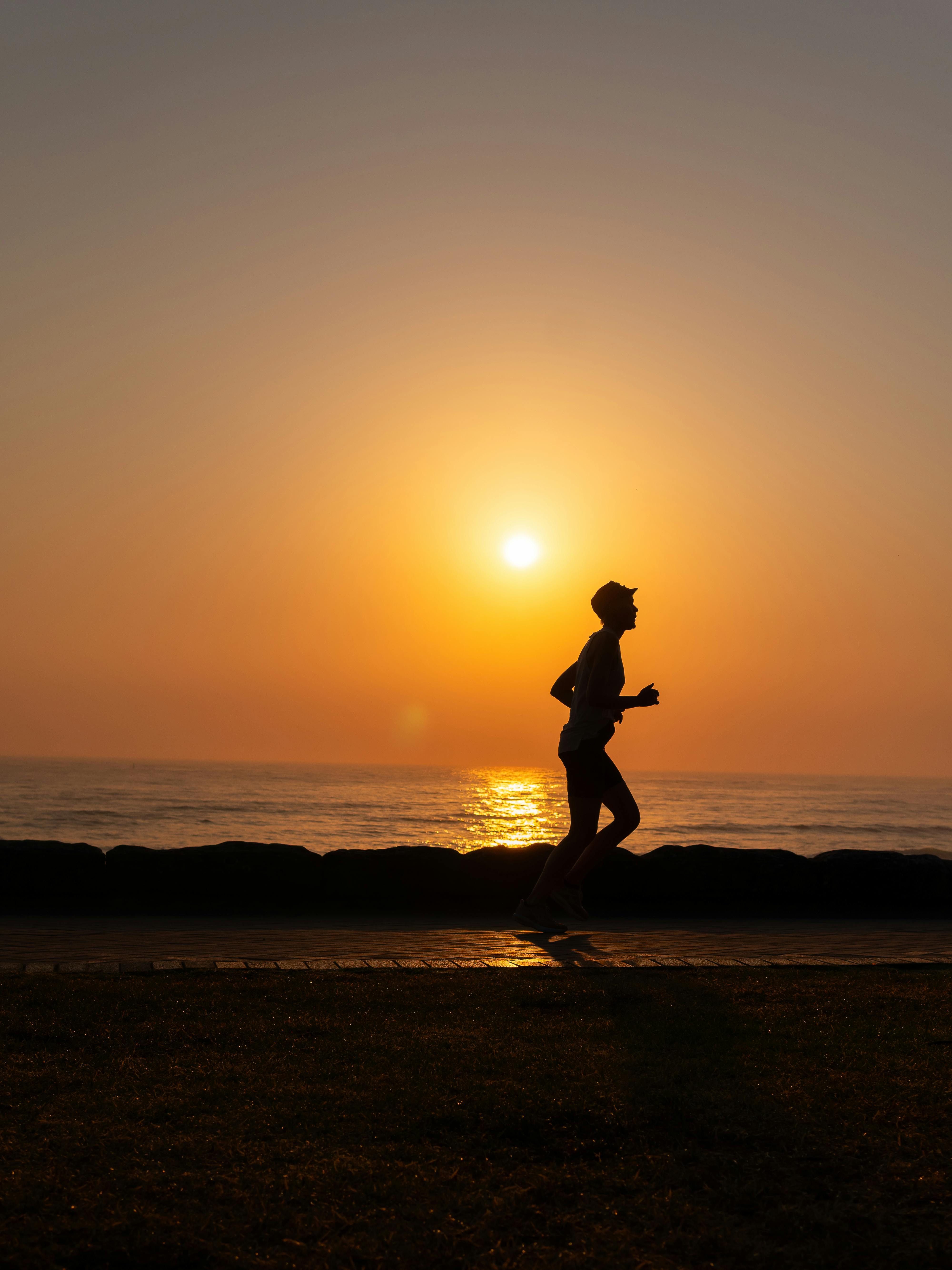 a-silhouette-of-a-person-running-along-the-ocean-shore-during-a-picturesque-suns - talha-resitoglu (pexels)