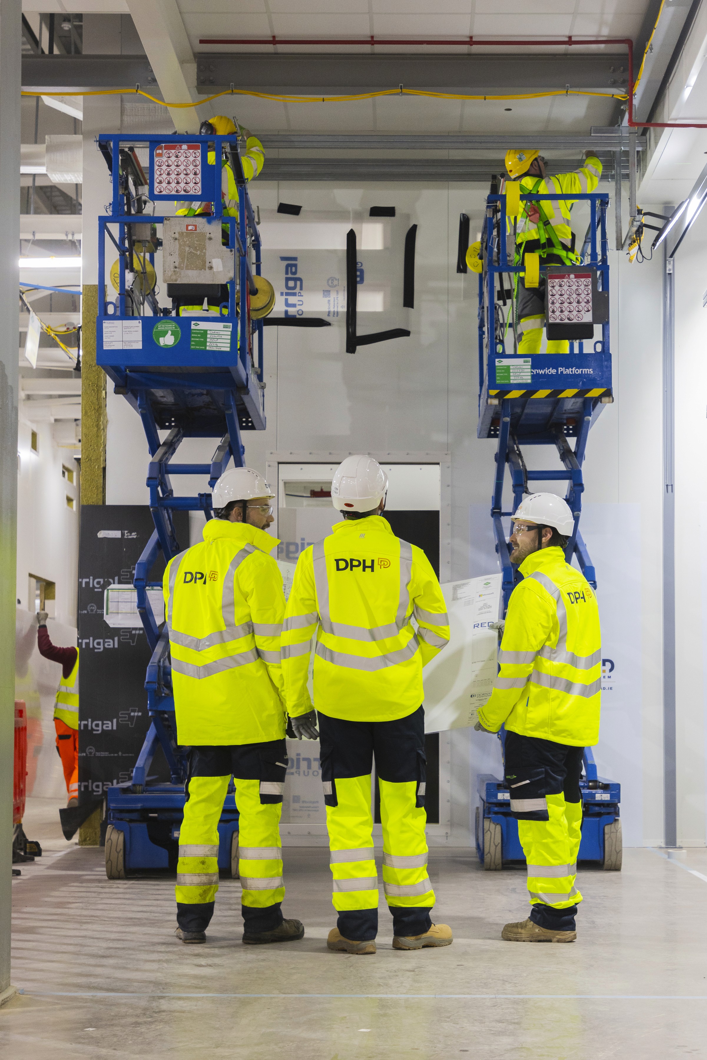 Rooftop garden with trees and plants, overlooking a cityscape at sunset with a tall building in the background