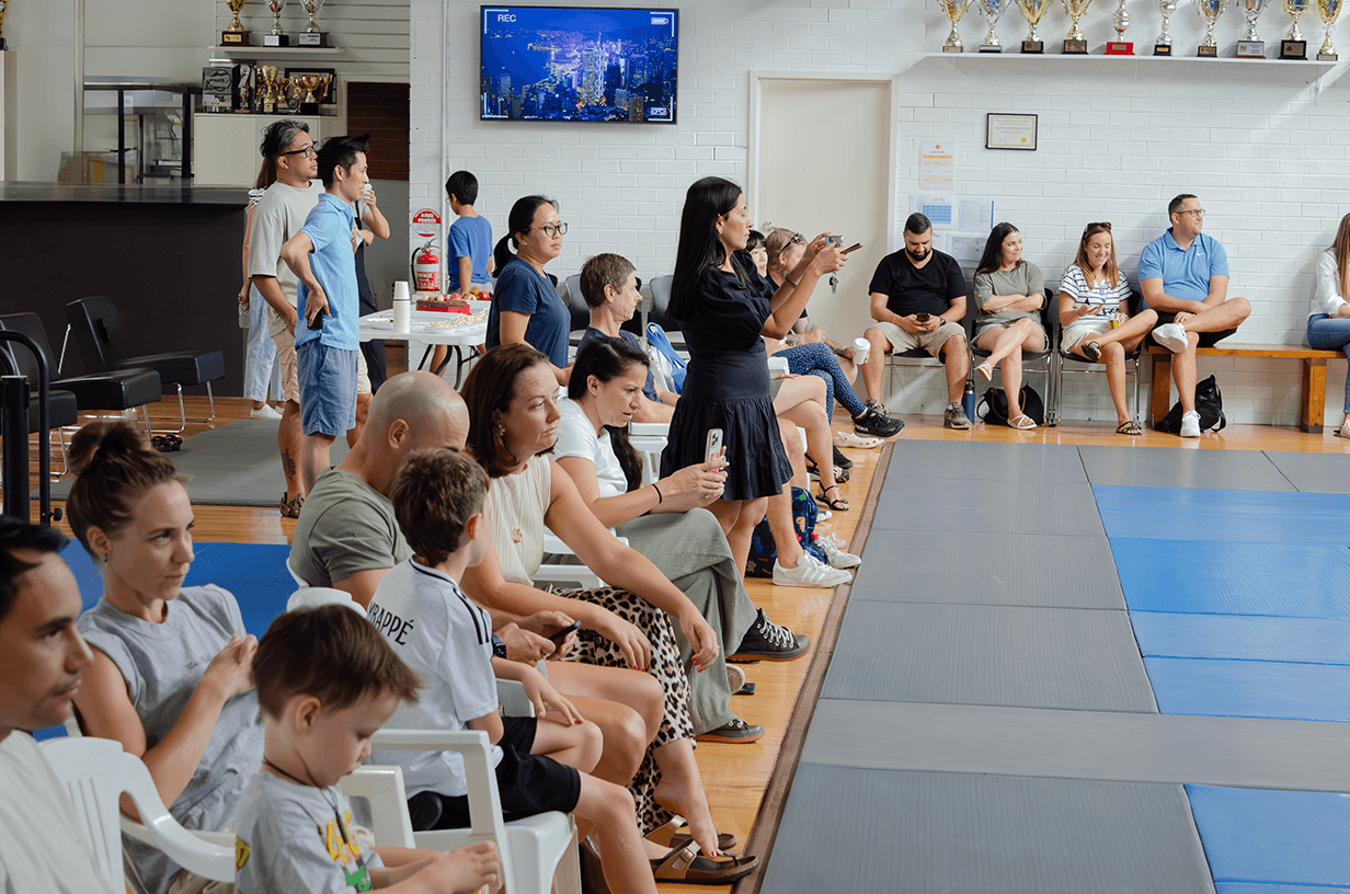 Families and children seated in the academy watching a live class