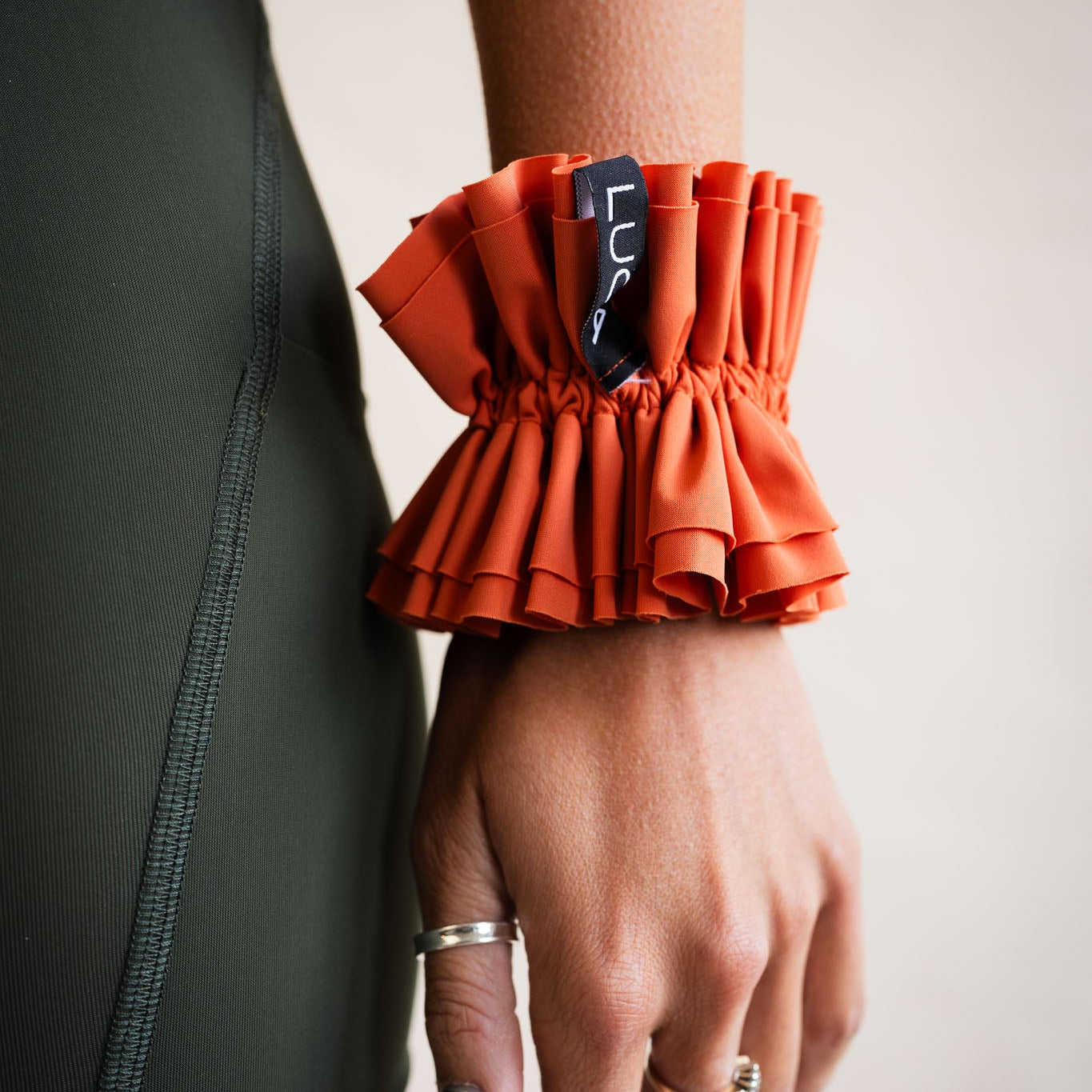 LUCA Uplift scrunchie in aperol worn on wrist