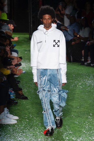 a model walks down the runway showing an off-white branded hoodie