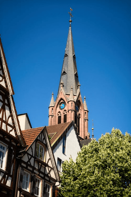 Large house with a wrap-around balcony overlooking a lit pool and deck at night.
