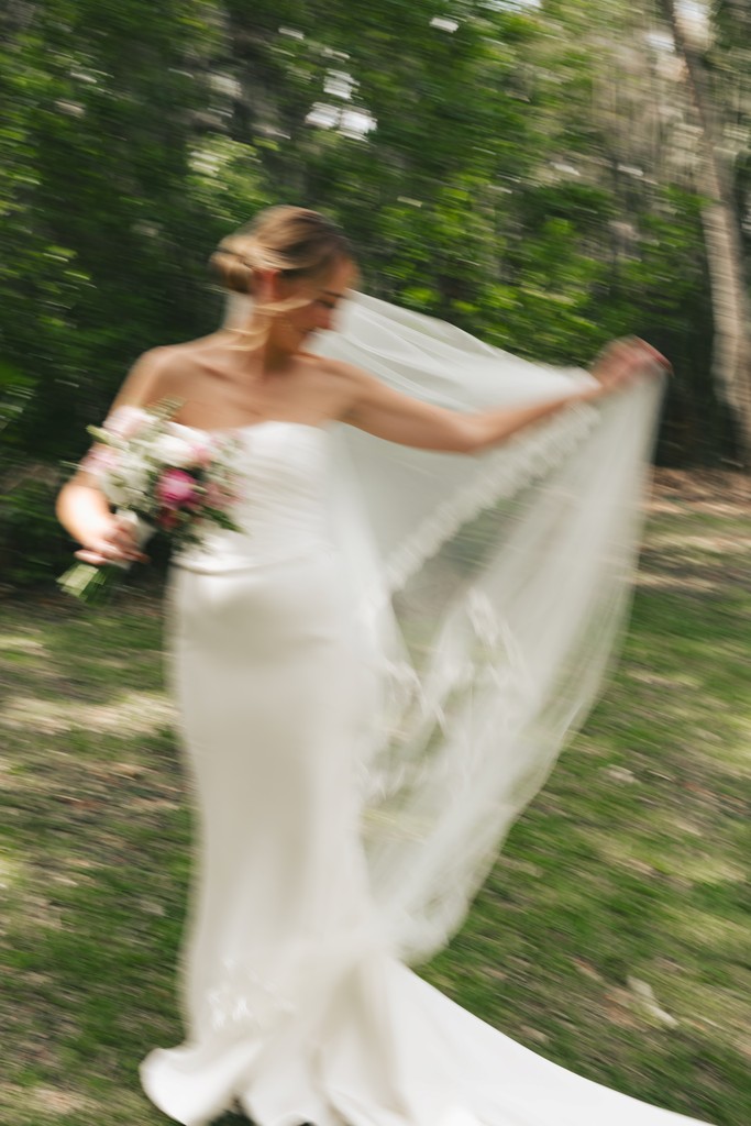     Wedding photographer in South Florida captures a bride twirling her veil outdoors in a romantic editorial wedding portrait.