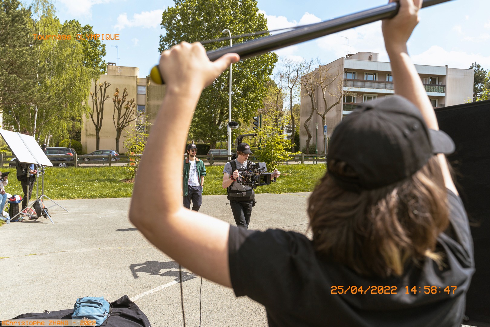 Tournage en extérieur avec équipe technique et caméra mobile.
