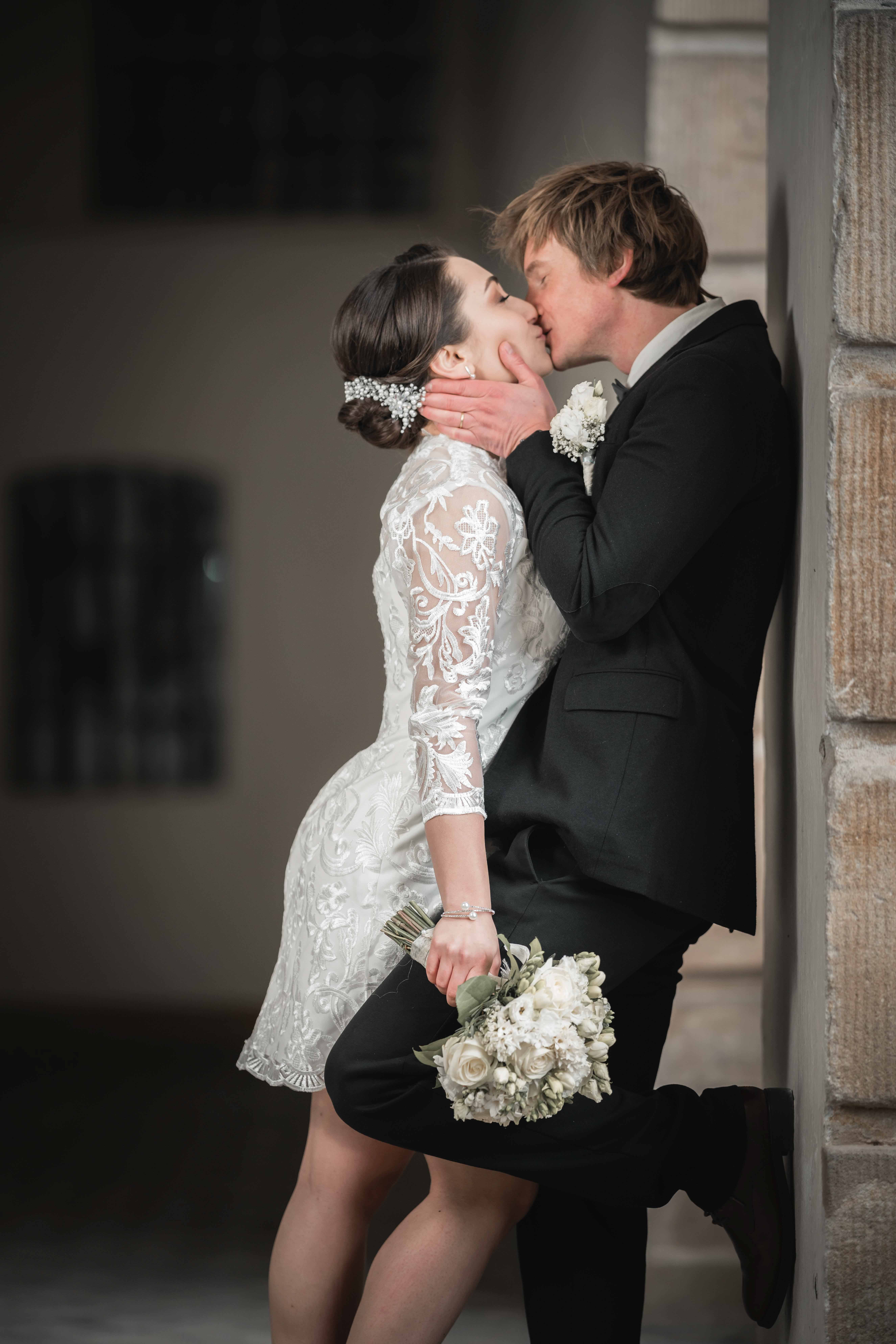 A bride in a lace wedding dress gently holds.