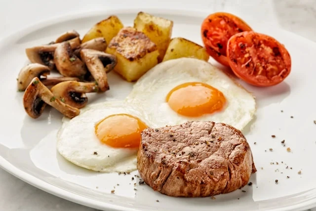 Grilled ribeye steak and eggs representing a high-protein carnivore meal.
