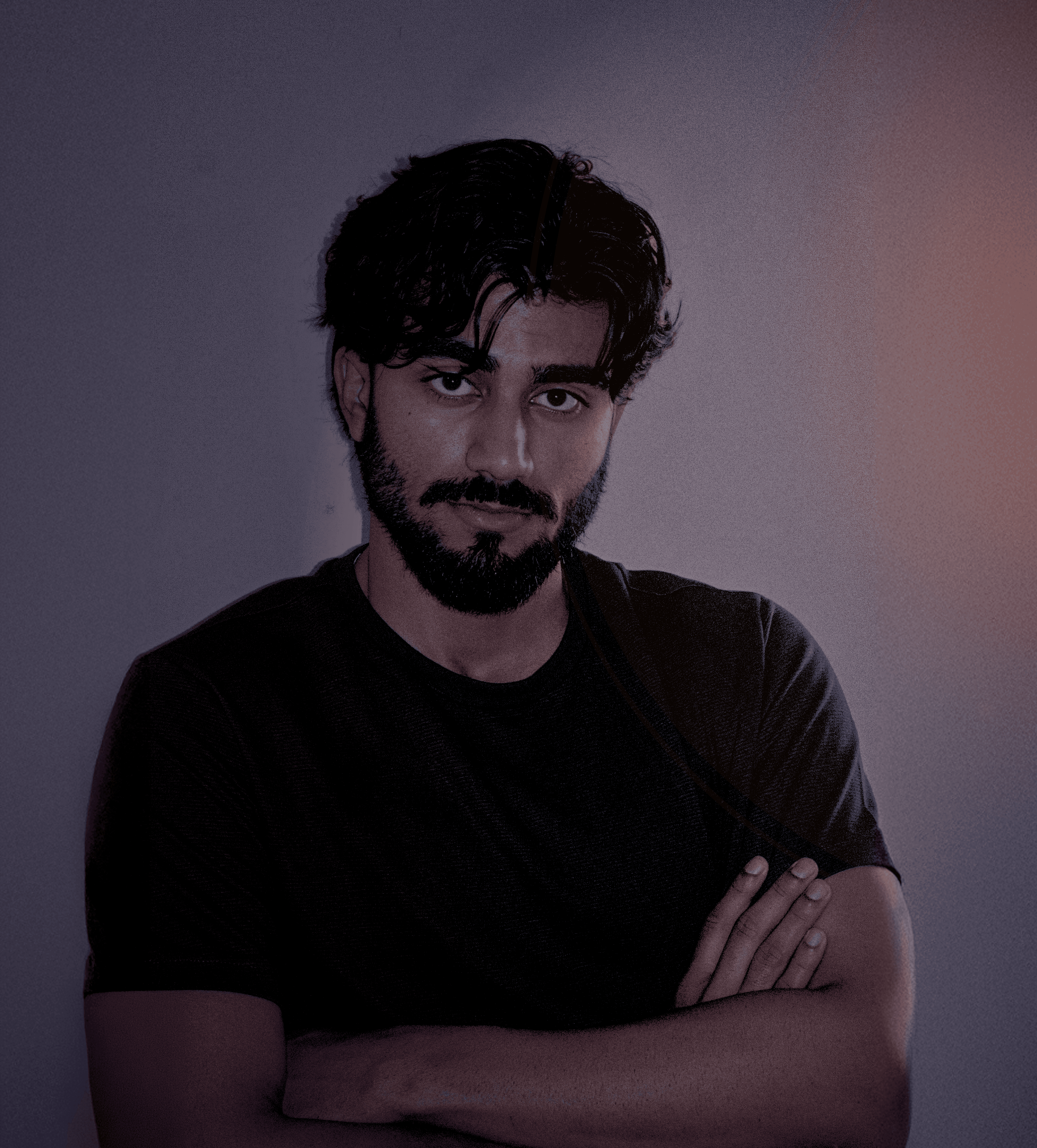 Picture represents a designer standing with arms crossed, wearing a black Tee