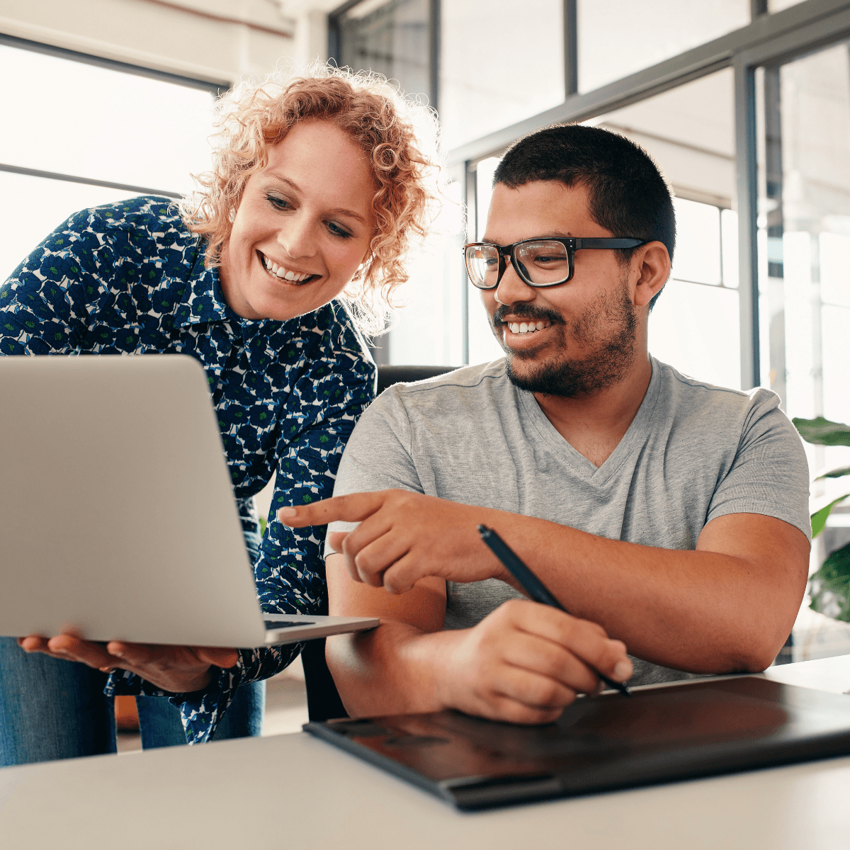 Two colleagues looking at the Clinials Content Hub for clinical trials on a computer at their desk