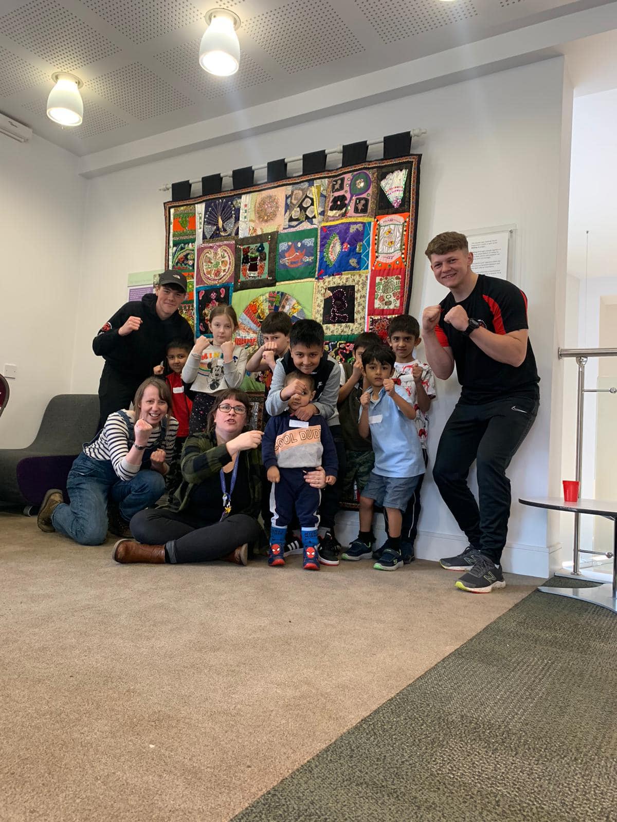 Father and son watching soccer with foam finger and popcorn.
