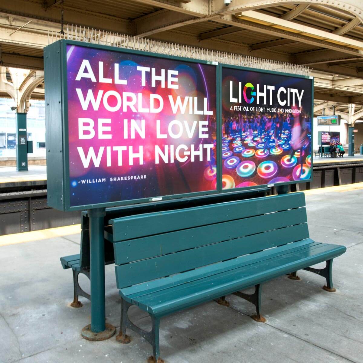 A train station bench sits in front of two large signs; one displays a quote about night, and the other advertises an event called Light City.