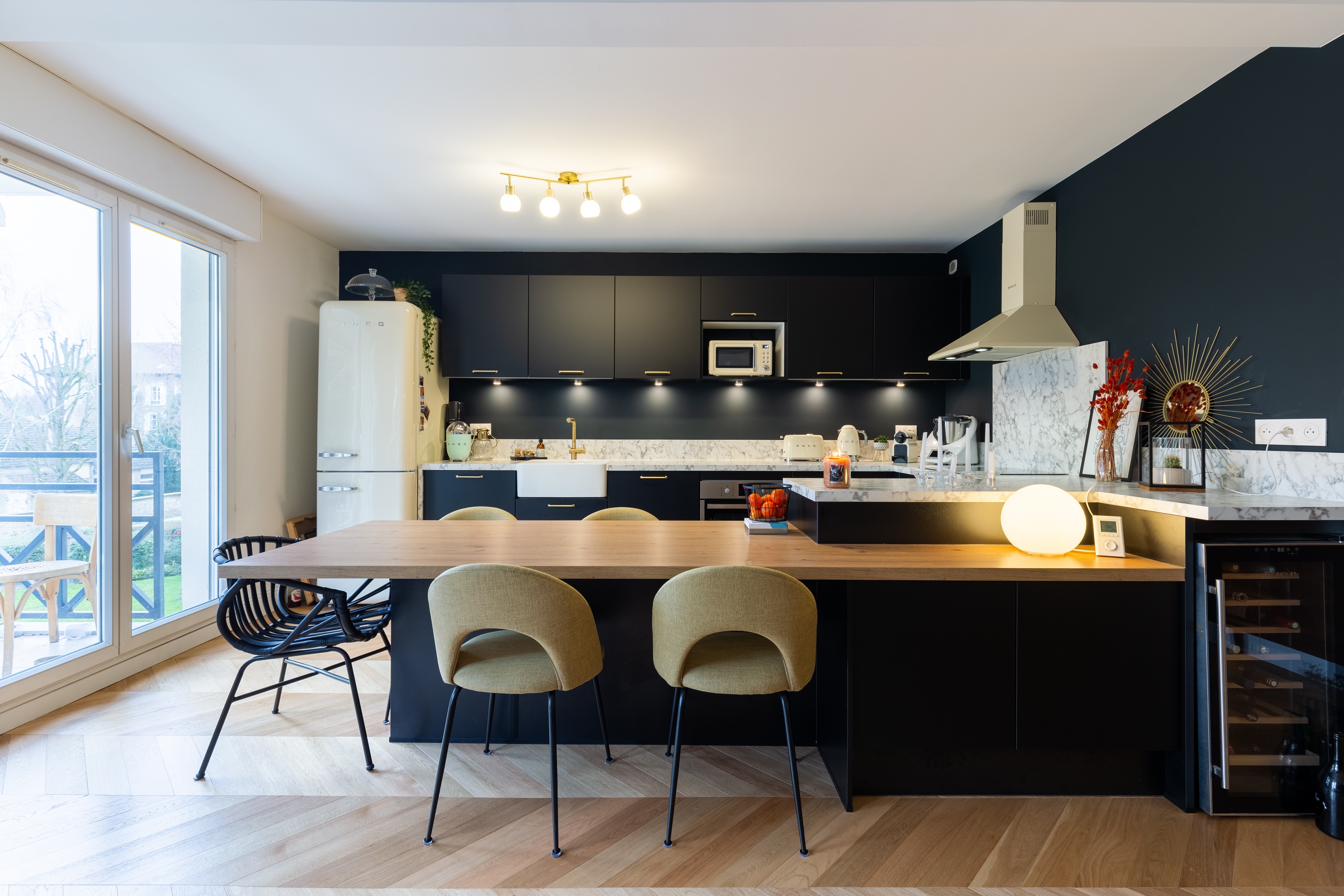 Rénovation douche minimaliste 77 avec grand pommeau plafond, murs pierre texturée et carrelage gris clair, architecte d'intérieur clé en main.