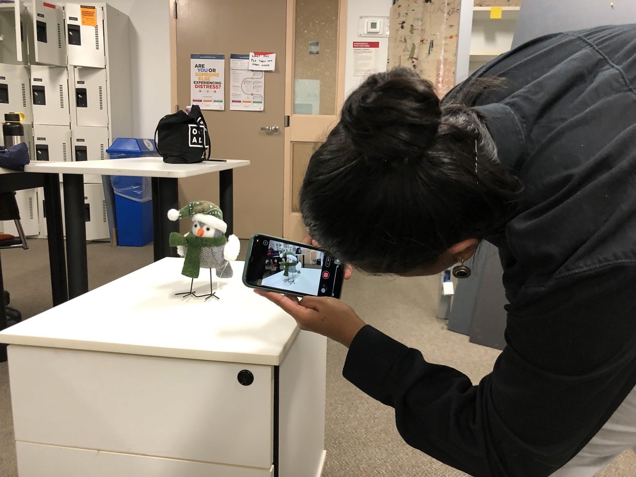 A participant uses a phone to scan a personal object for inclusion in the shared mixed reality environment.