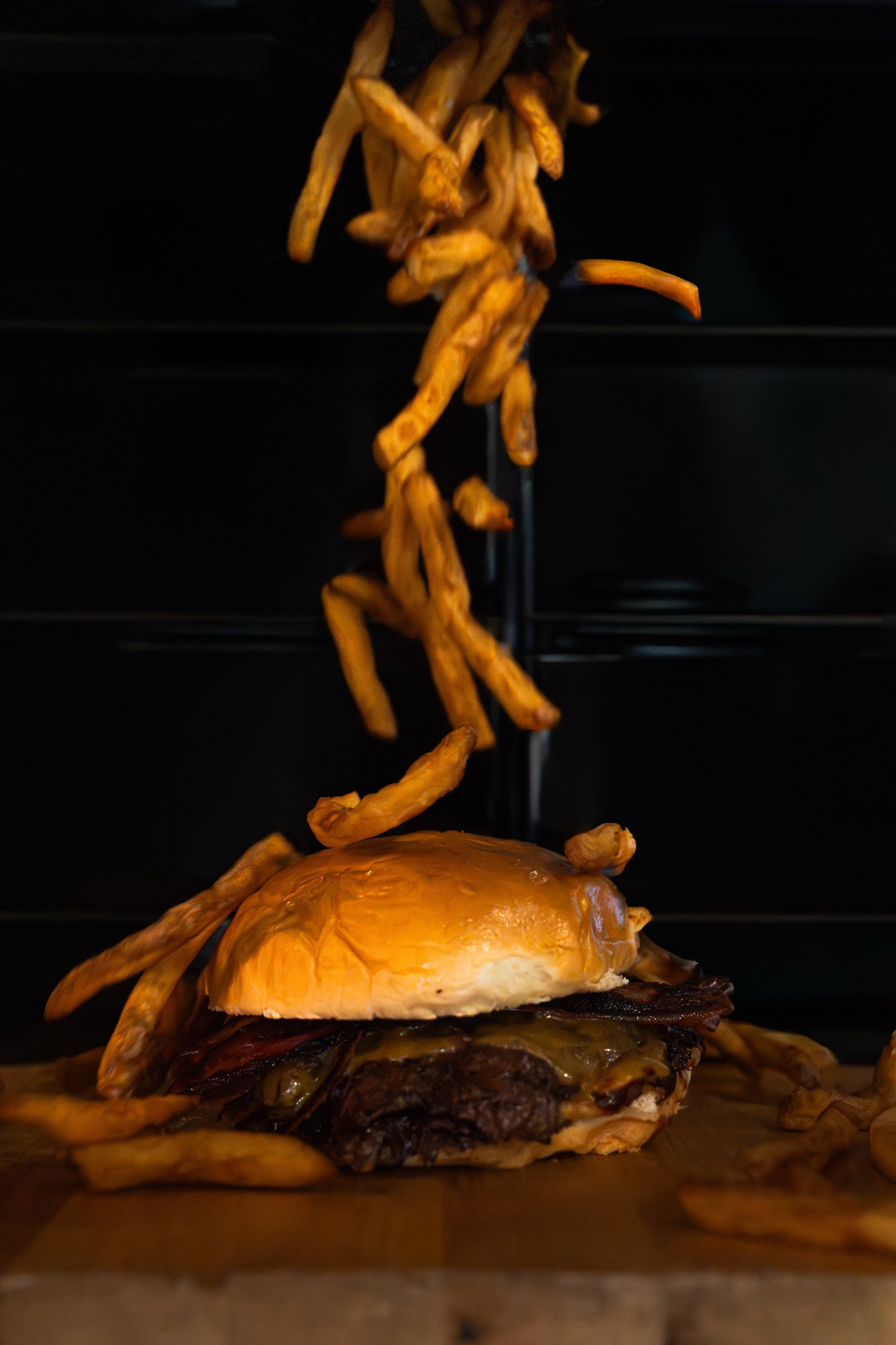 Smash burger con patatas fritas cayendo sobre ella