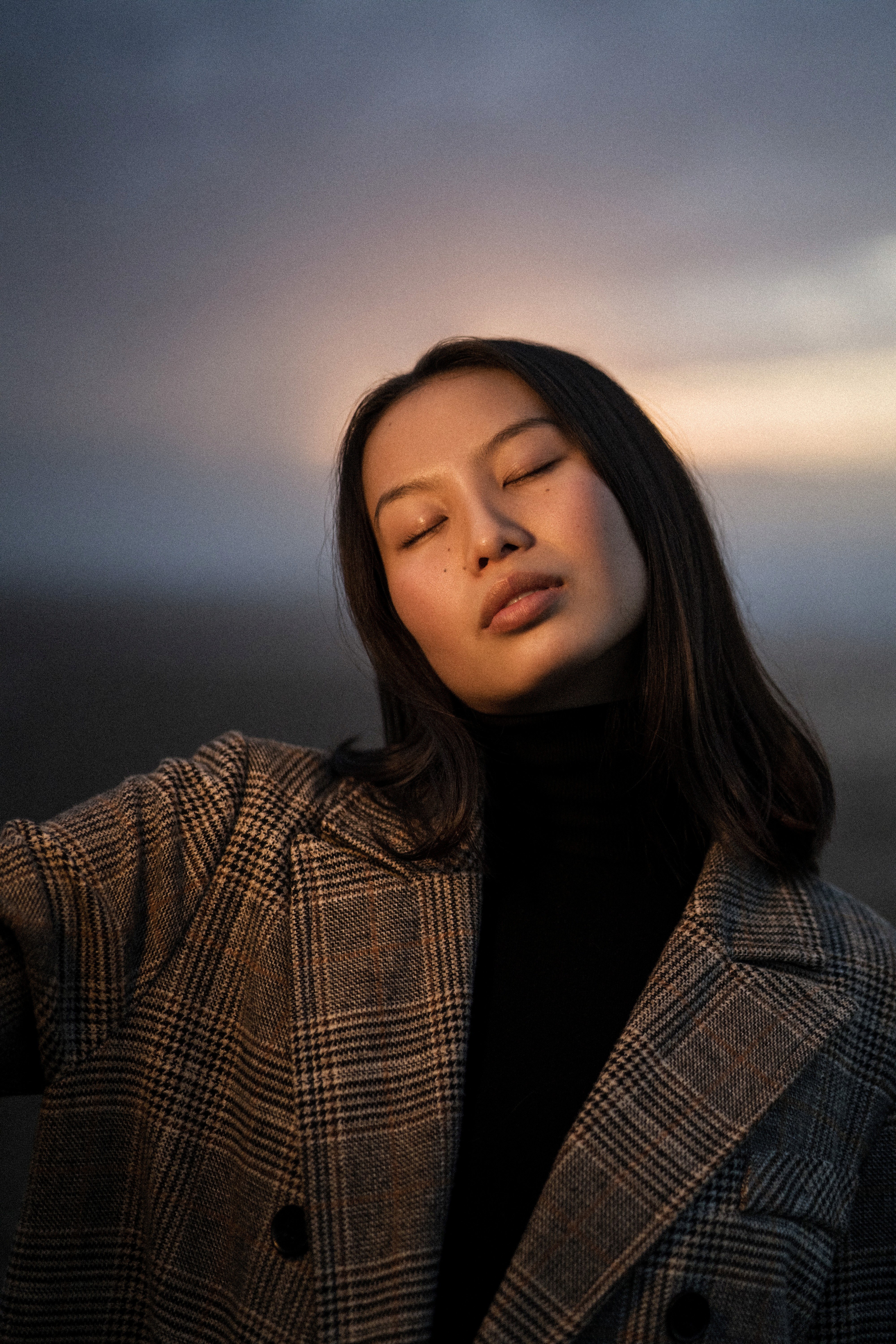 Front view of a calm Asian woman without wrinkles, outdoors in natural light.