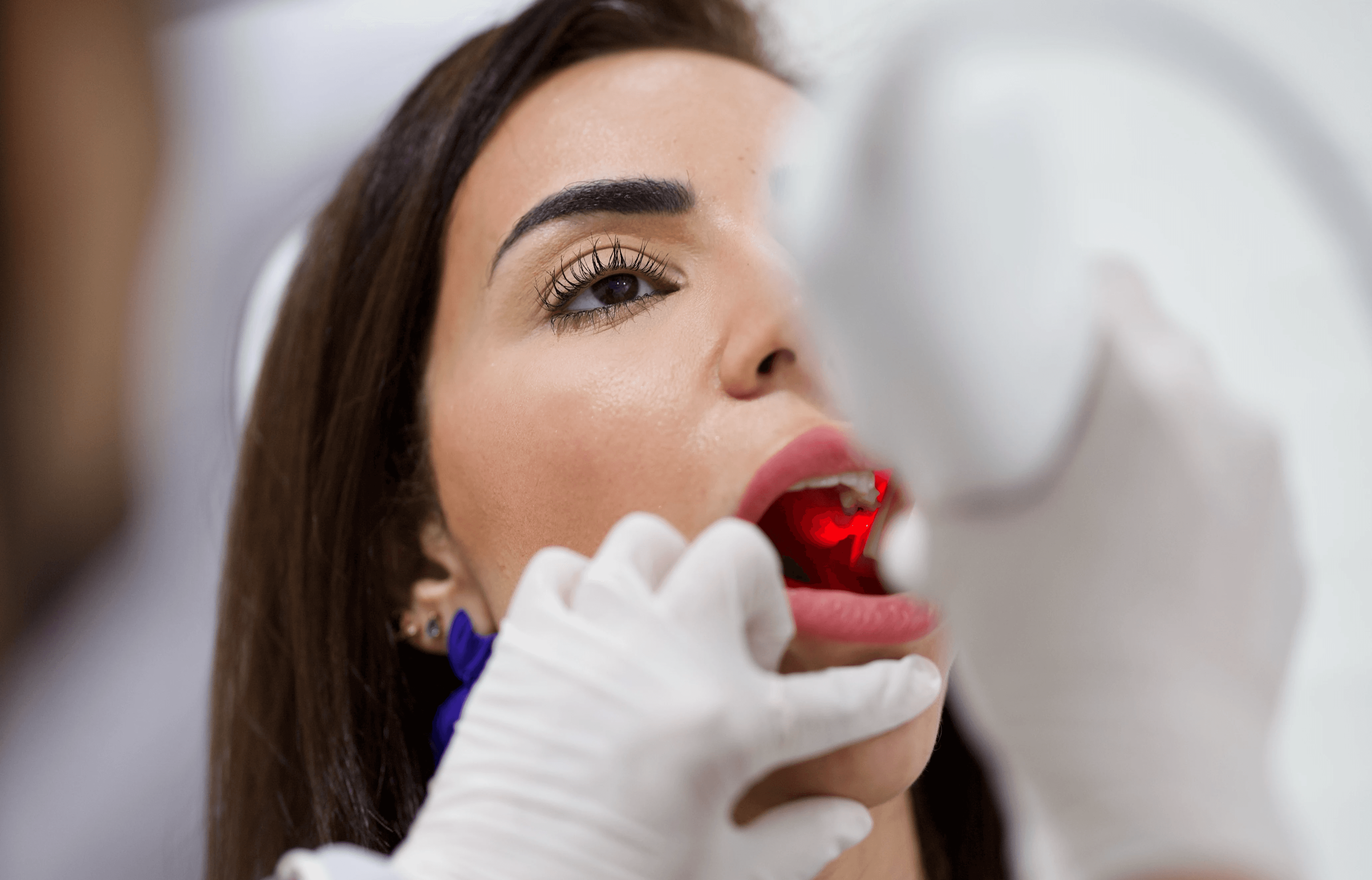 A patient having her jaw checked by an expert dentist, addressing queries such as can ear wax cause jaw pain, by Invisalign Center