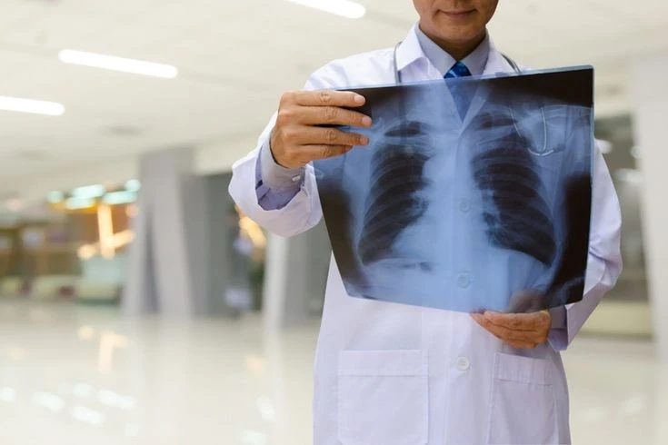 A radiologist looking at a X-ray of a Patient