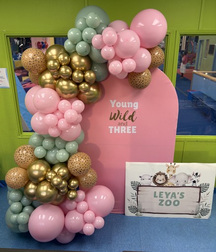 Balloon arch with big 15 inch balloons and 7 inch ballloons in the colours black, purple and blue. The arch is black and has happy birthday sign. The theme is based out of fortnite video game.