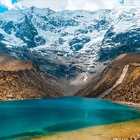 Lagoa de montanha com águas azul-turquesa cercada por picos nevados da Cordilheira dos Andes