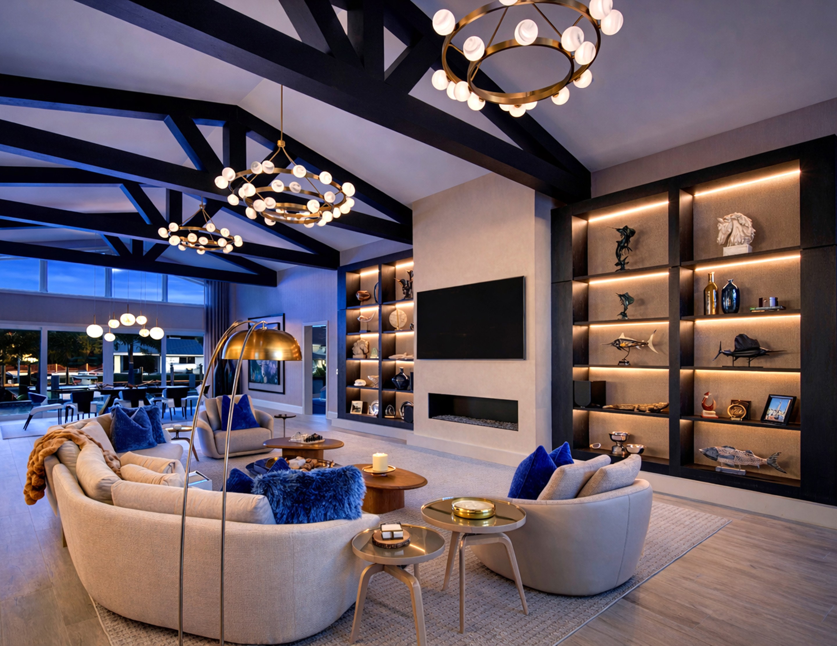 Layered luxury living room with sculptural lighting, built-in shelving, and warm modern finishes in Pompano Beach.