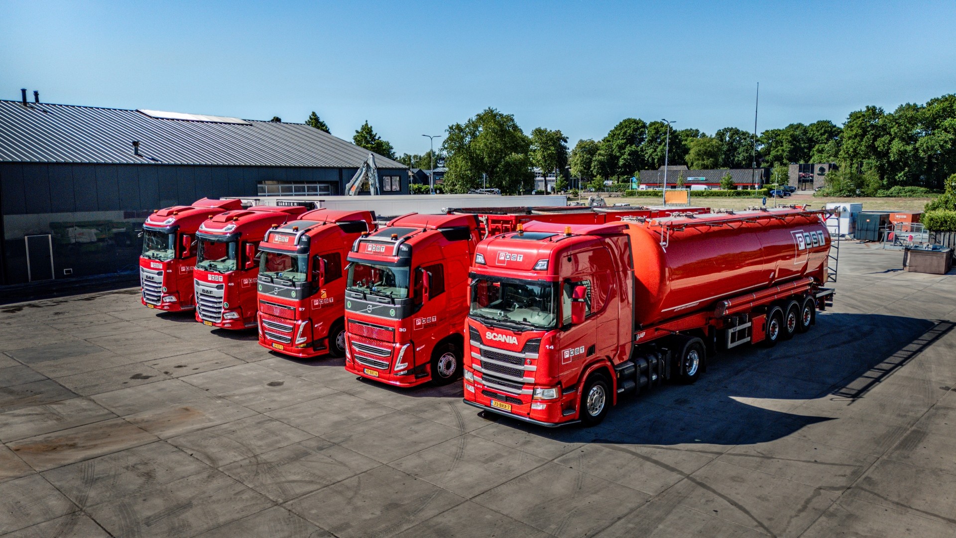 Diverse rode vrachtwagens van Post Handel en Transport