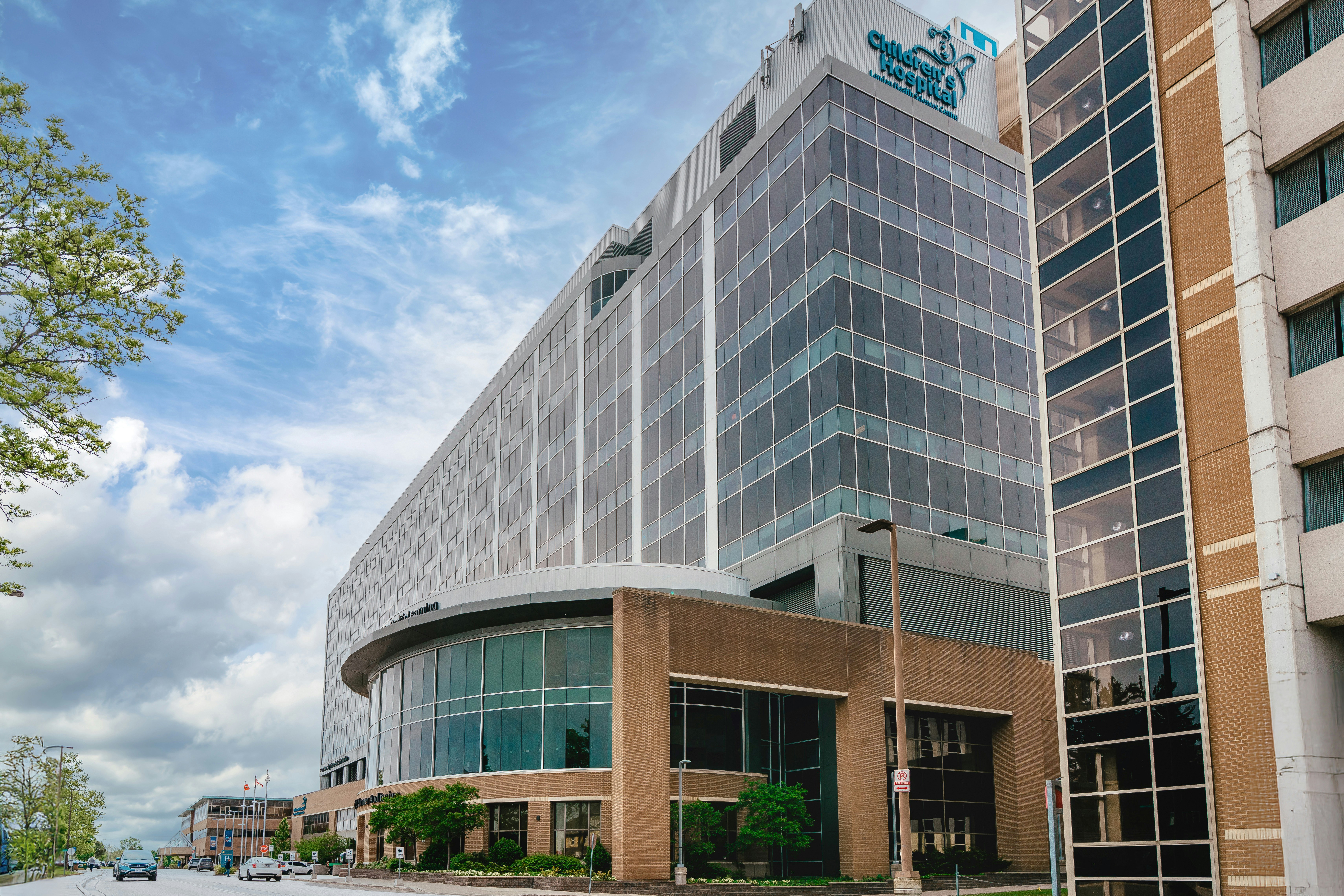 Modern glass building with curved entrance under sky.