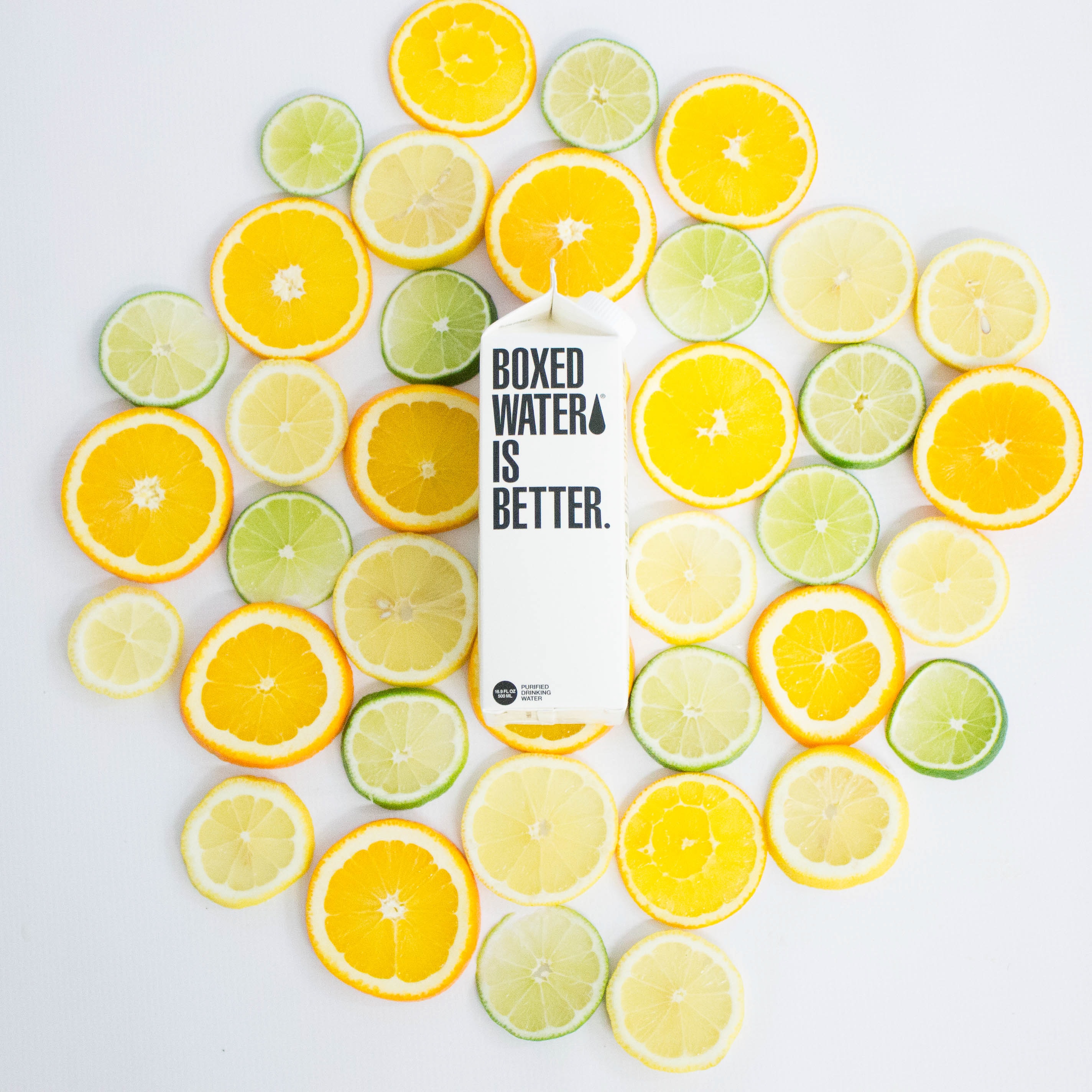 Boxed water surrounded by sliced citrus