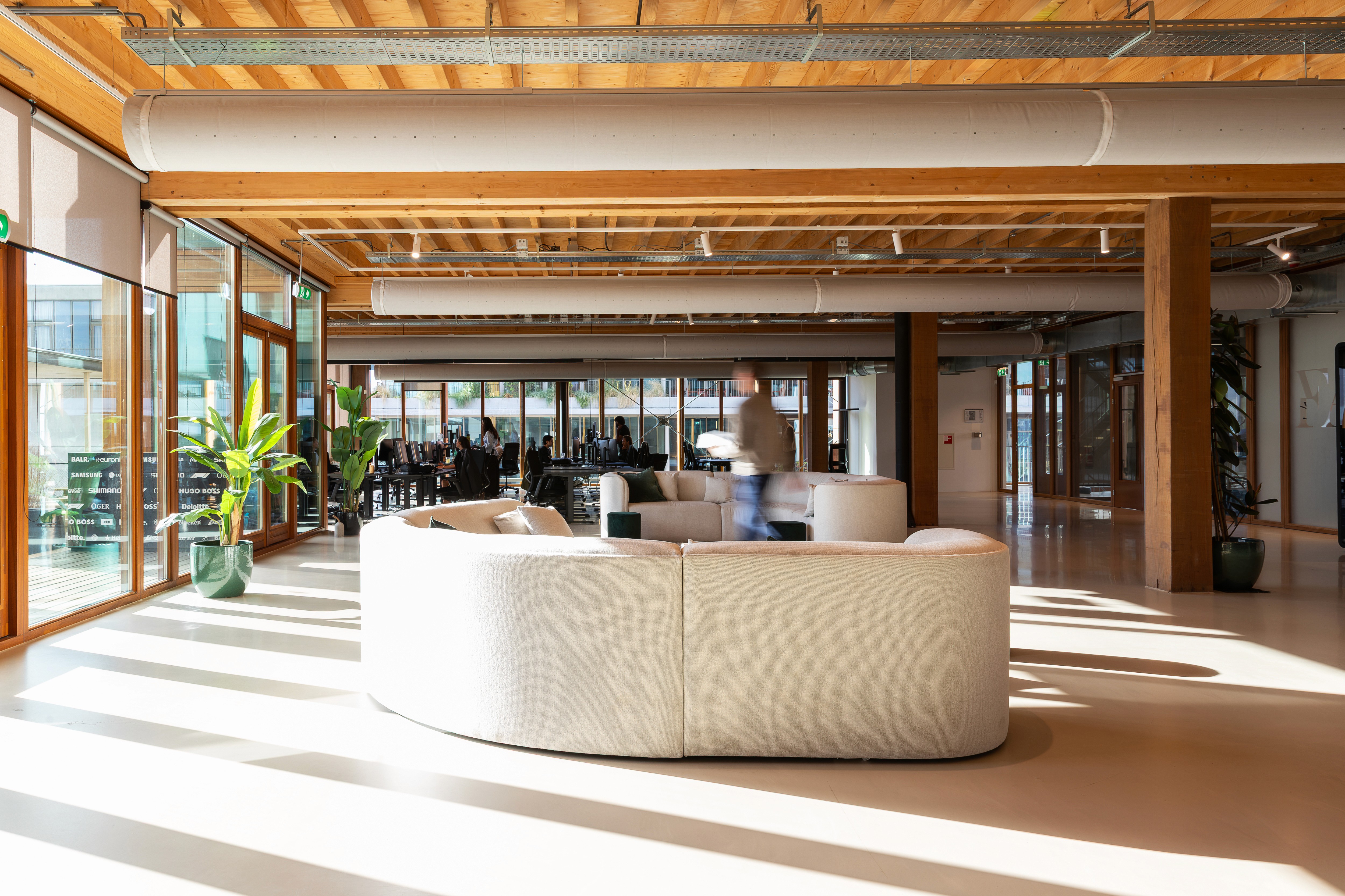Heller Loungebereich mit Holzdecke in einem Büro von Flatline Agency
