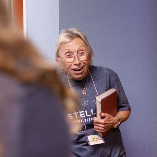 volunteer laughing while holding a Bible