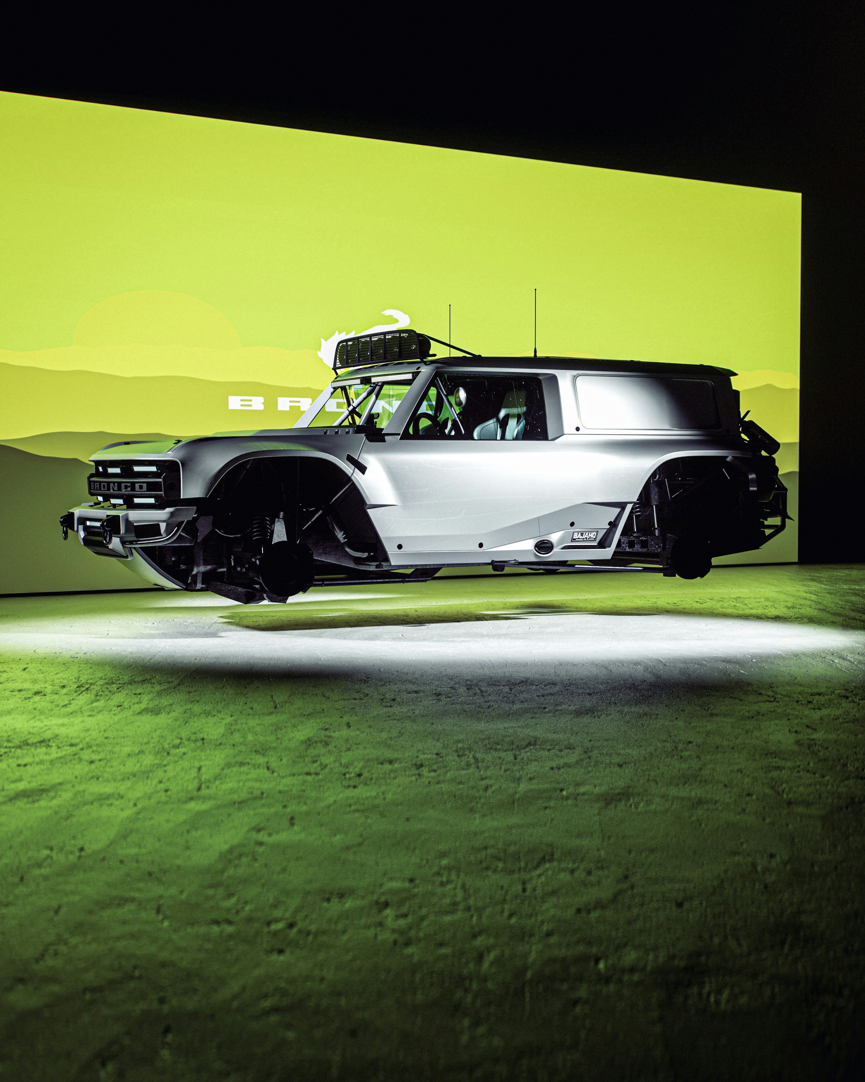 A silver car hovers above a grassy field.