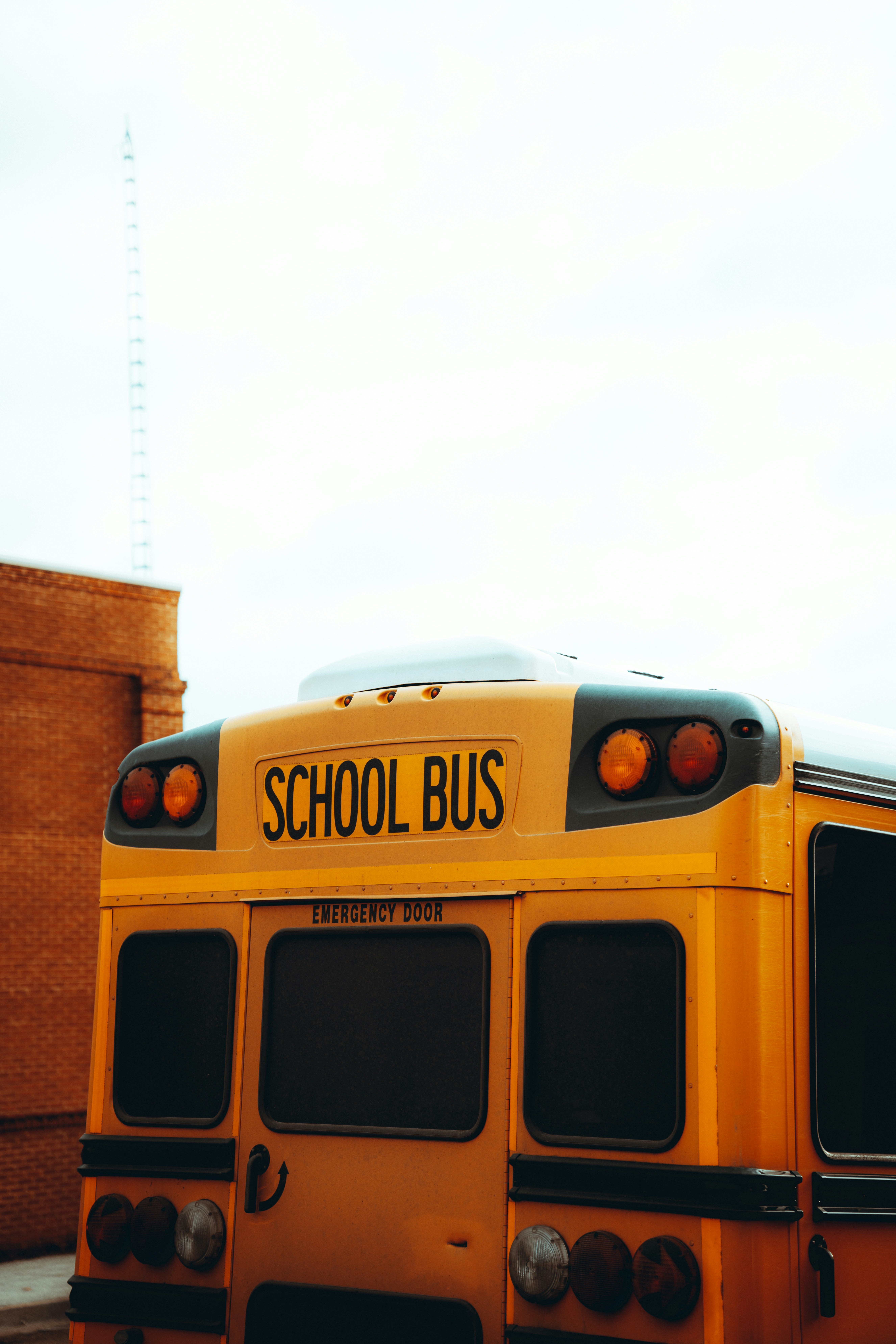 a yellow school bus parked in front of a brick building