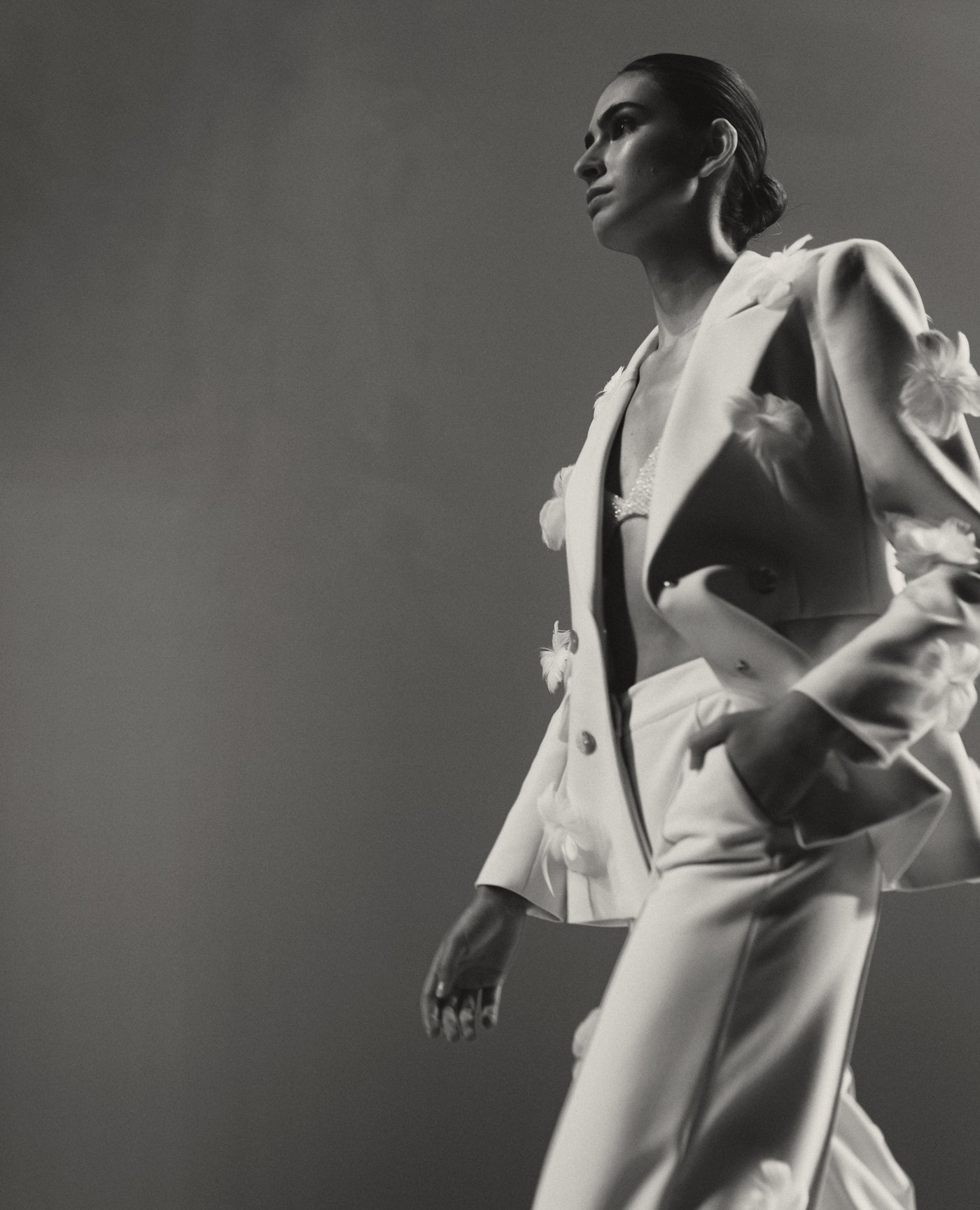 Model walking in an ivory satin suit