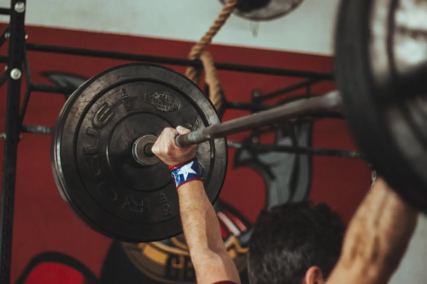 an olympic lifter standing with a barbell overhead after completing a snatch