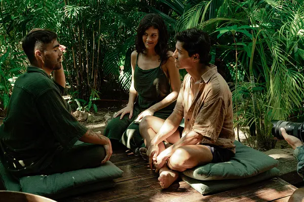 Three people chatting in the jungle at Nômade Tulum, Mexico.