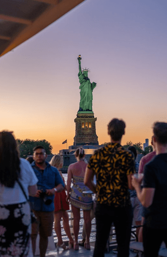 Pemandangan matahari terbenam Patung Liberty dari kapal pesiar