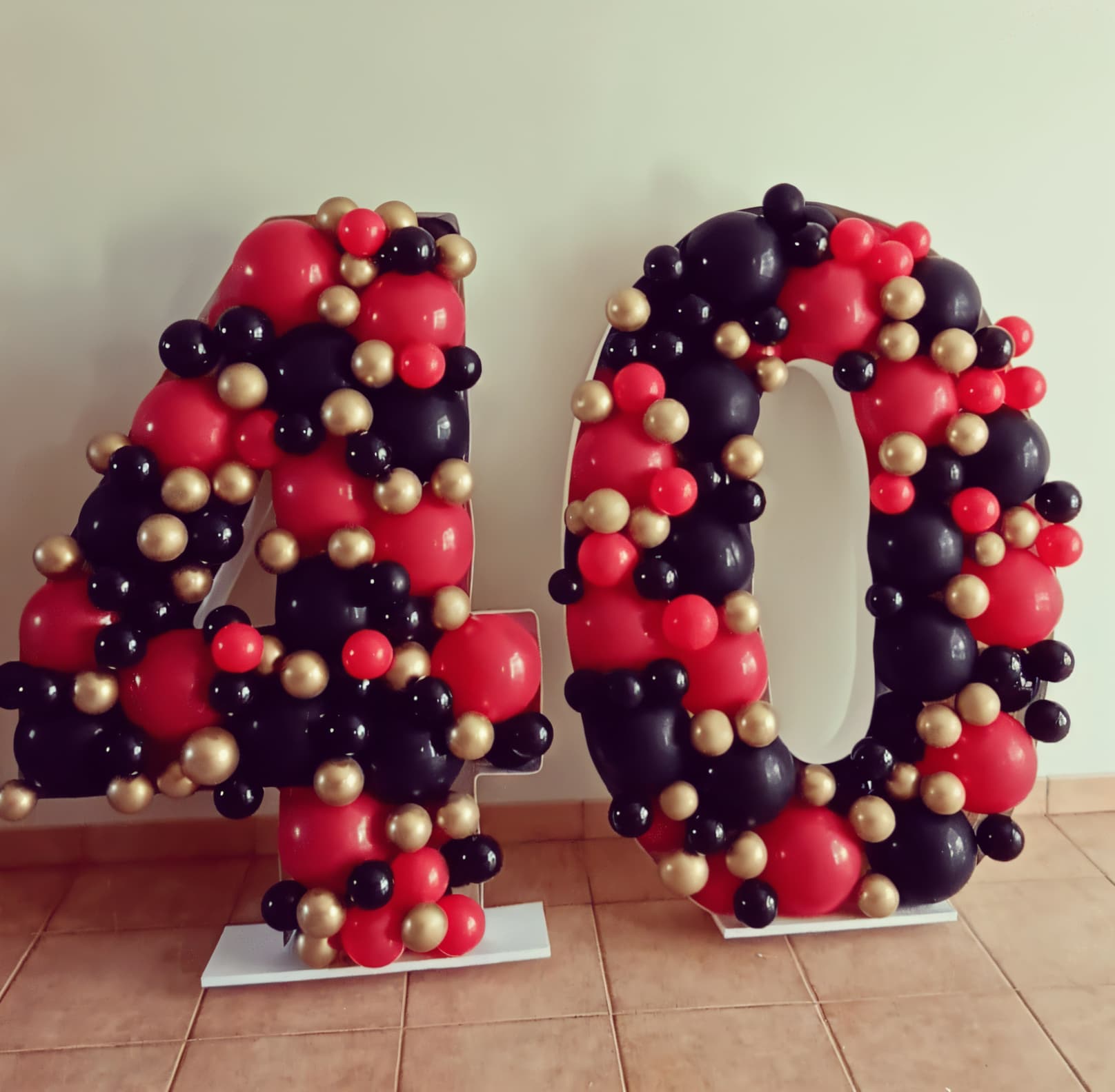 Chiffres géants garnis de ballons noirs, rouges et dorés pour fêter les quarantes ans