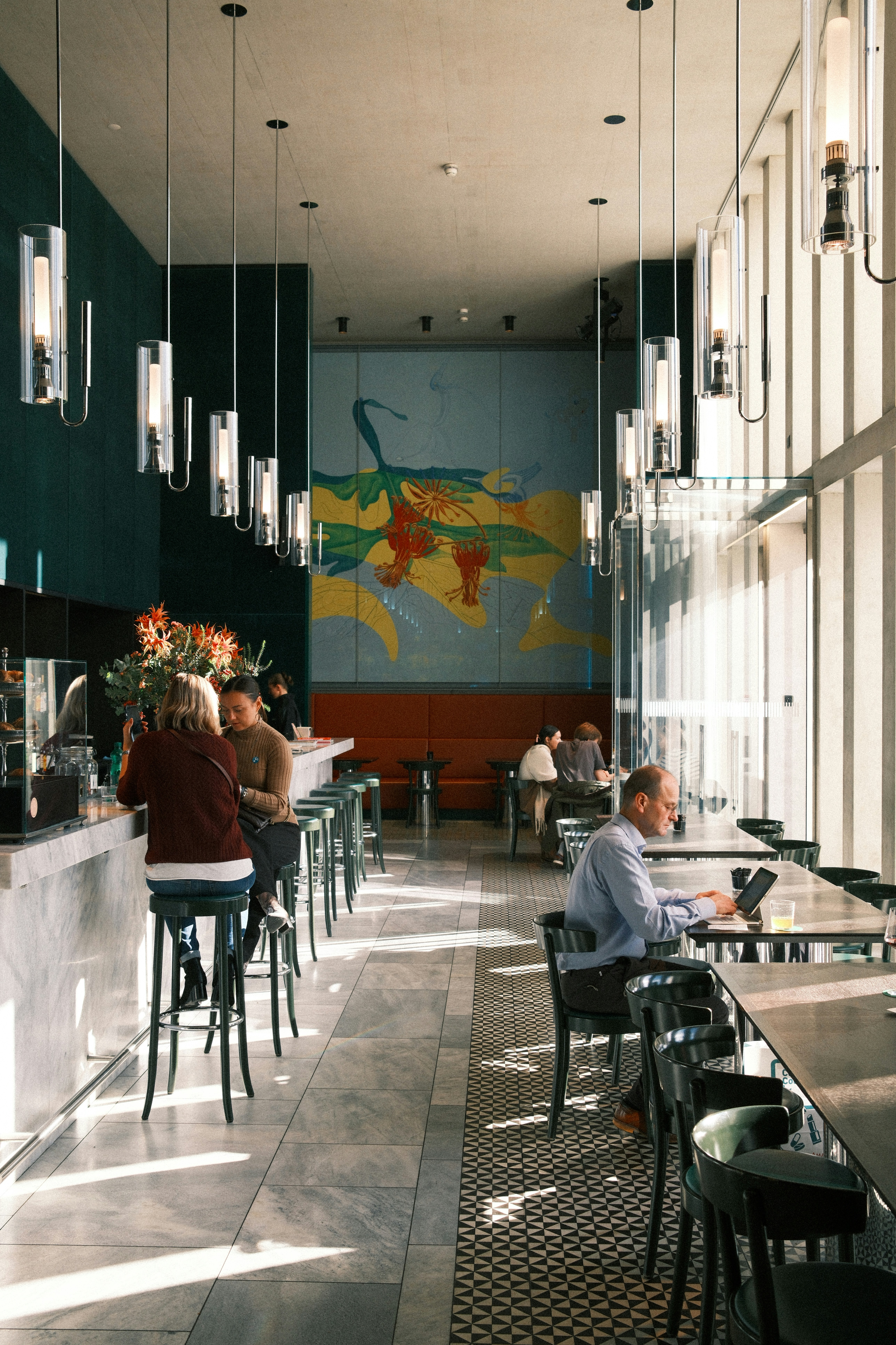 People dining and working in a modern cafe.