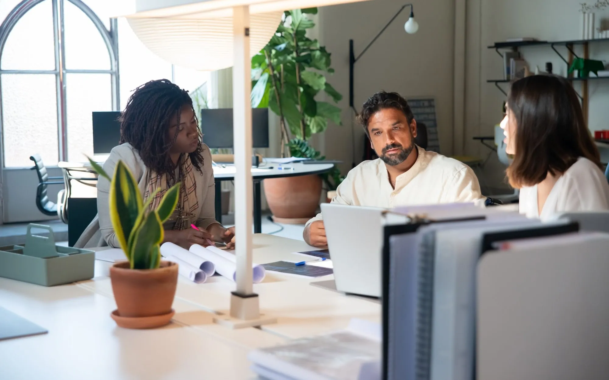 Colleagues working together around a desk in a bright office