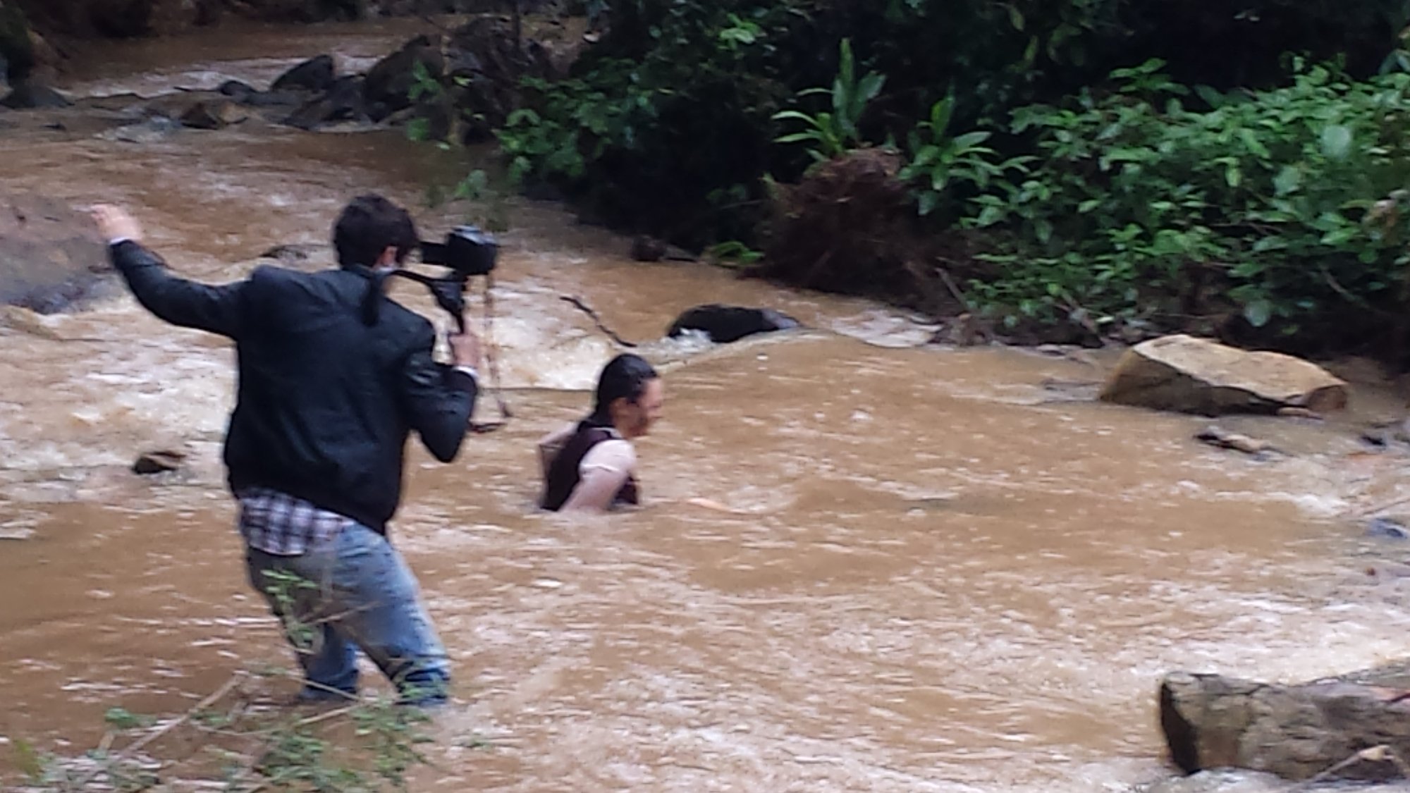 Cinegrafista entra no rio de água barrenta para filmar a atriz Vânia Leda na correnteza