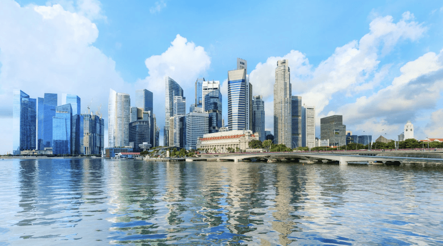 Modern glass building with illuminated trees and a view of city skyscrapers