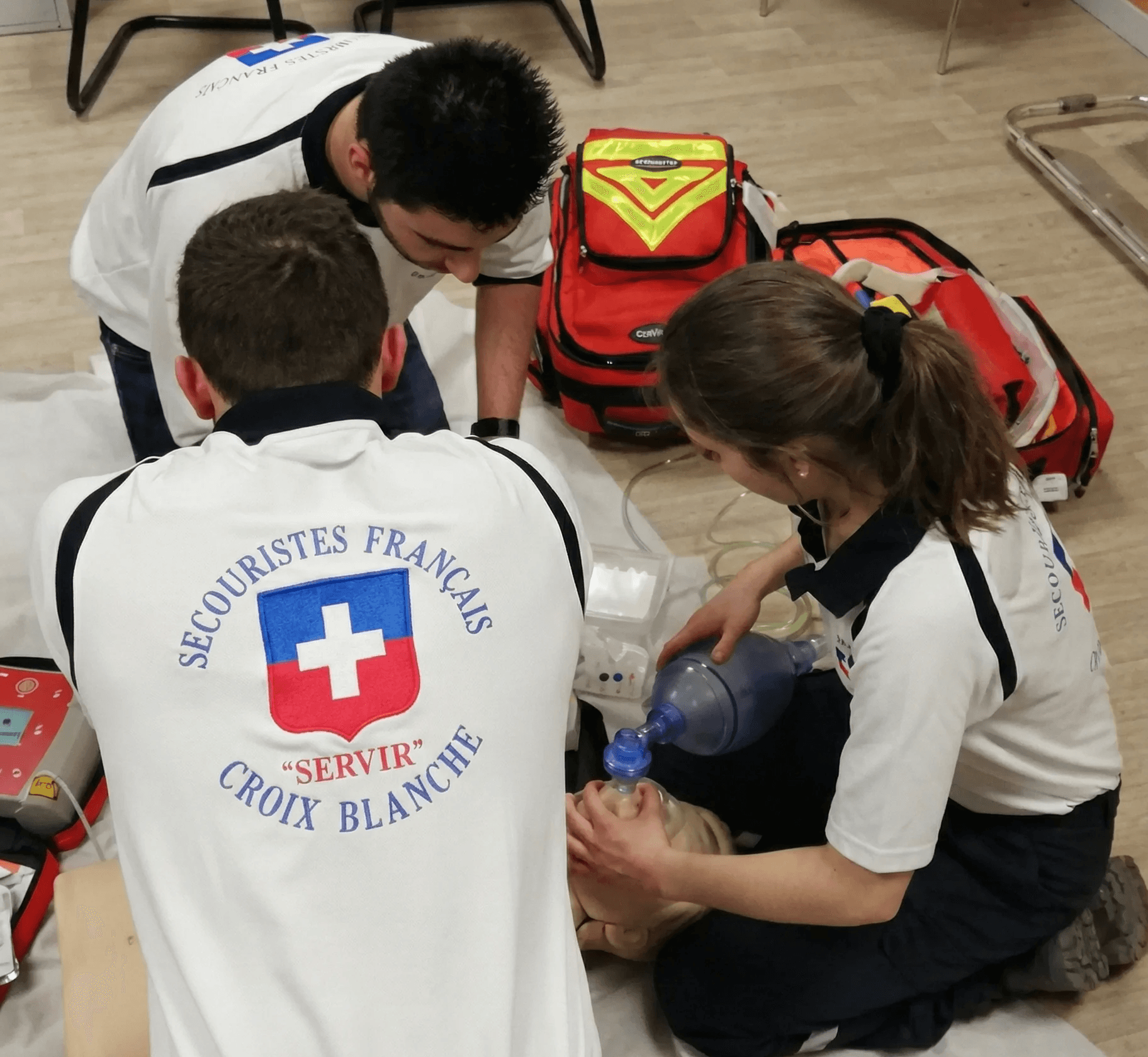 Secouristes Français Croix Blanche pratiquant des soins d'urgence avec équipement médical.